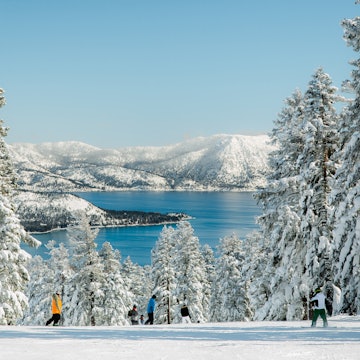 People skiing on top of a mountain with view of Lake Tahoe on a snowy winter day, with trees fully cover by fresh snow.
1132149163
snow, scenics - nature, landscape - scenery, winter, nature, forest, cold temperature, mountain, tree, sky, frozen, ice, season, panoramic, lake, travel, frost, woodland, environment, pinaceae, beauty in nature, non-urban scene, skiing, travel destinations, pine tree, tranquil scene, mountain range, weather, truckee, lake tahoe, reno, california, south lake tahoe