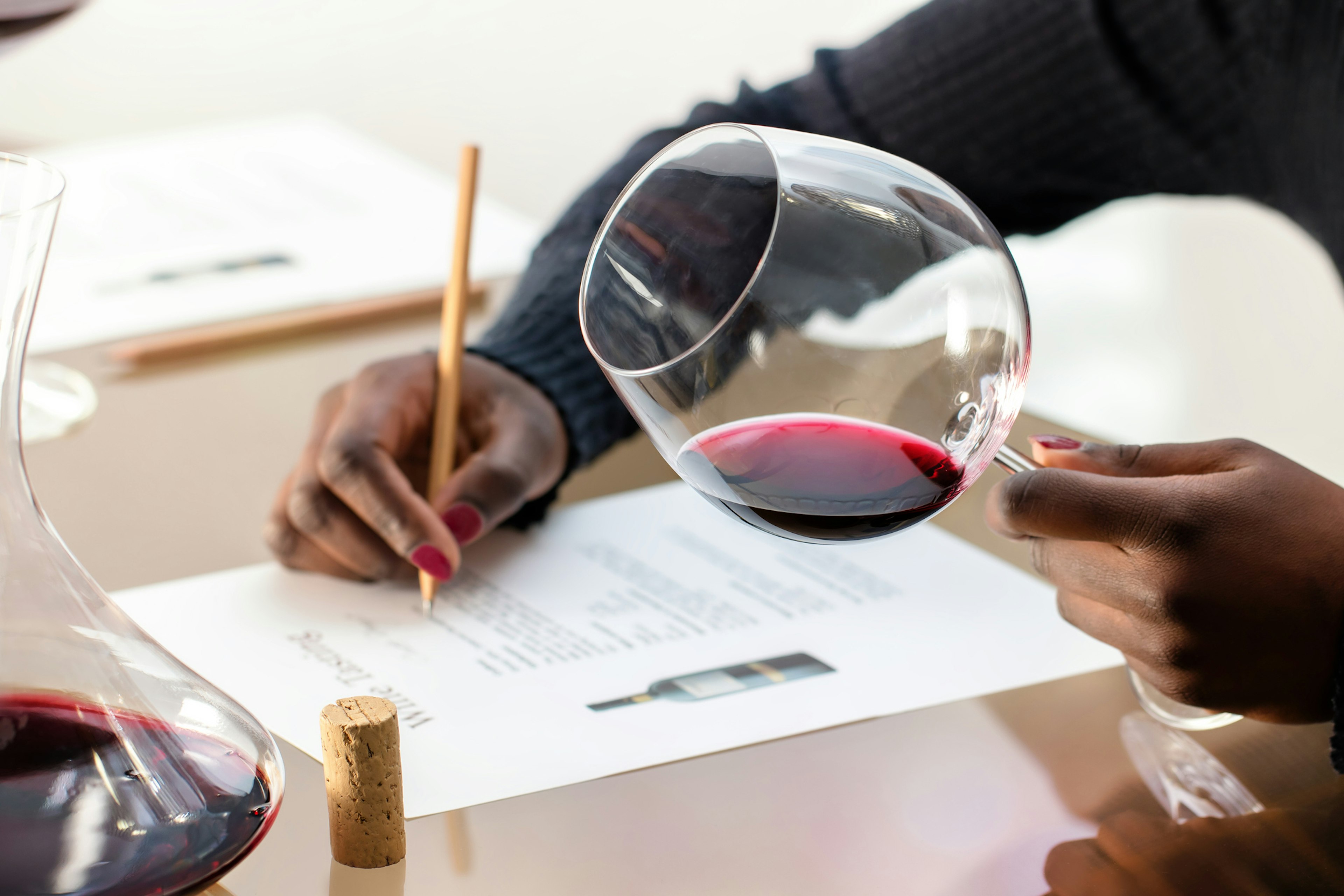 Enologist evaluating red wine at wine tasting.