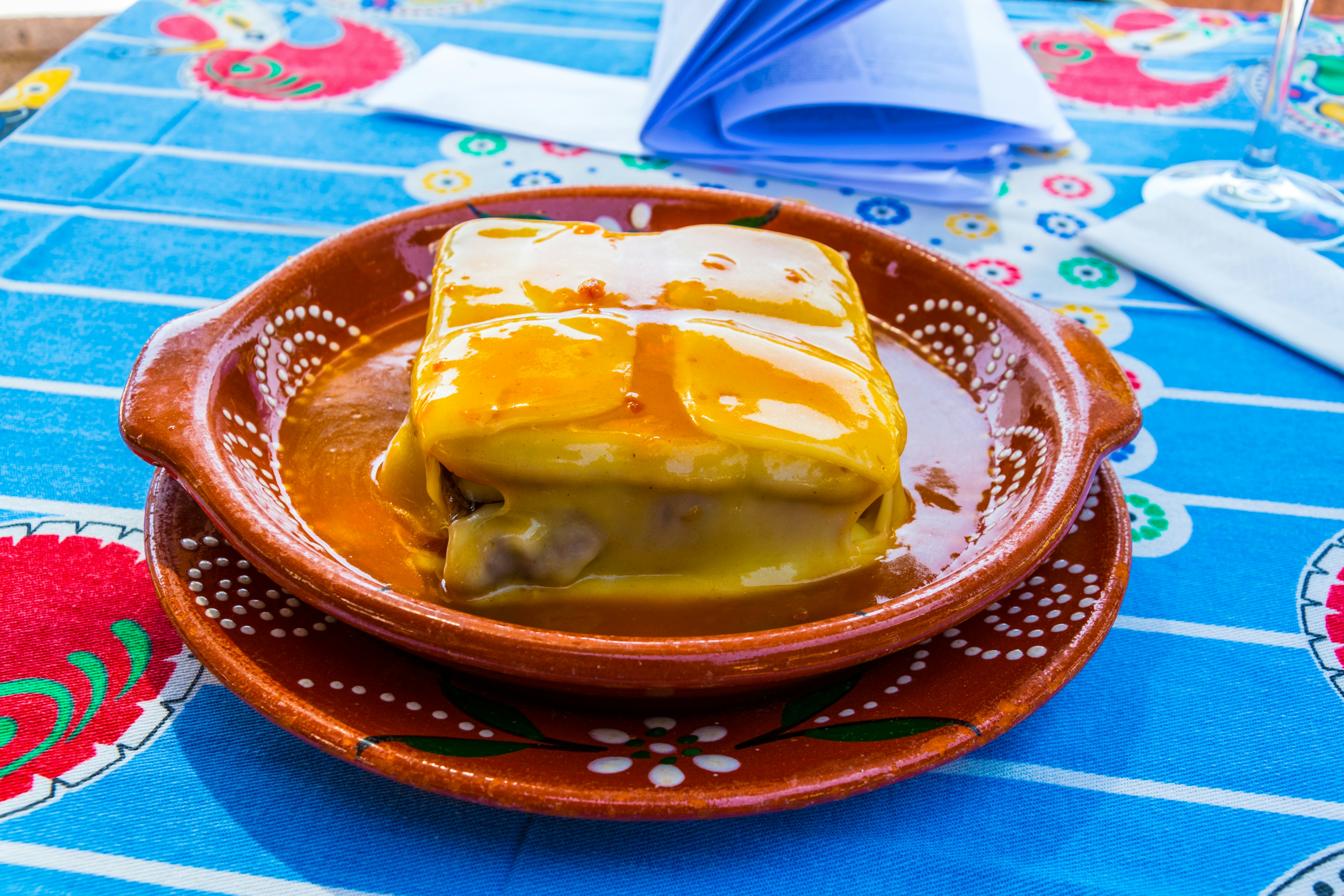 A francesinha sandwich on a typical Portuguese table cloth.