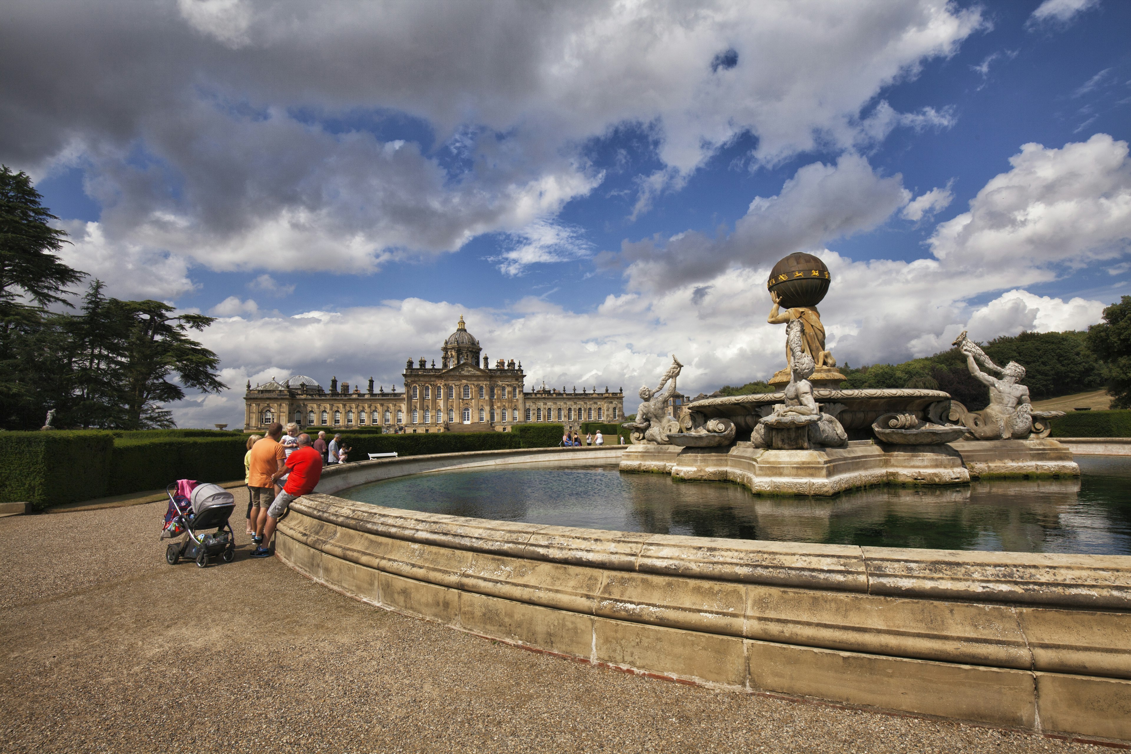 Tourists seen around the fountain in front of Castle Howard on a sunny afternoon, North Yorkshire