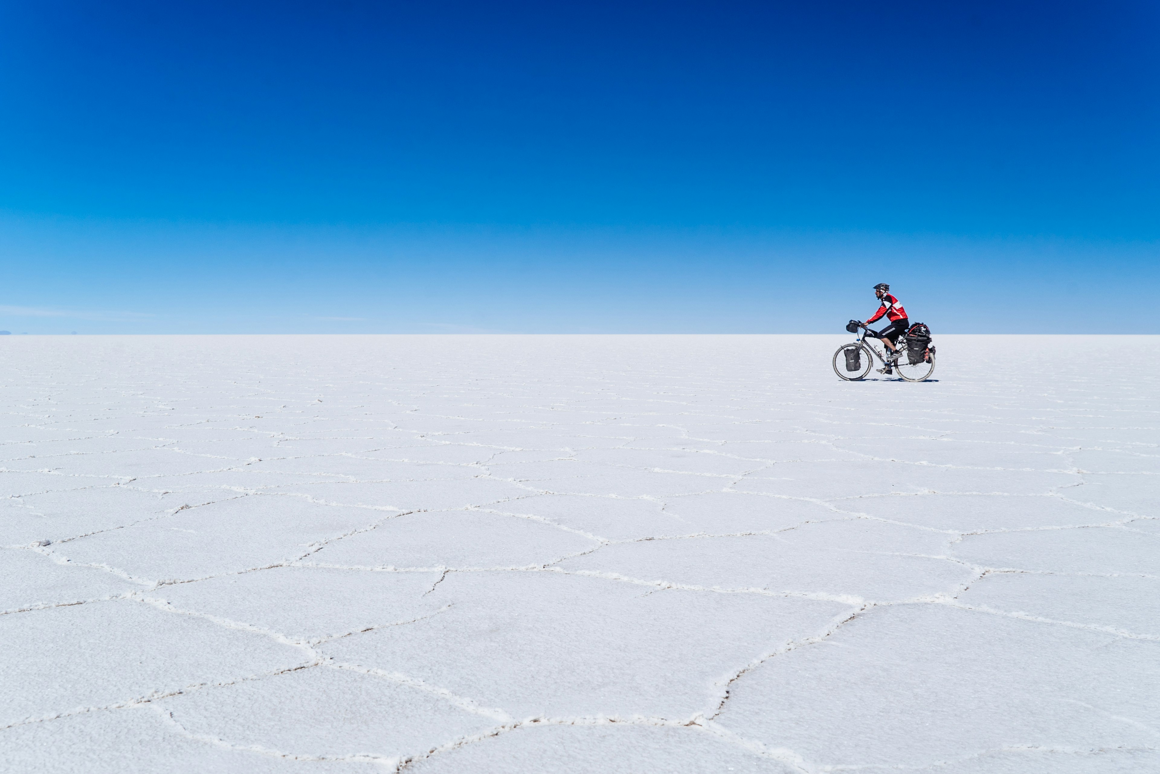 A long-distance cyclist passing through the Salar De Uyuni