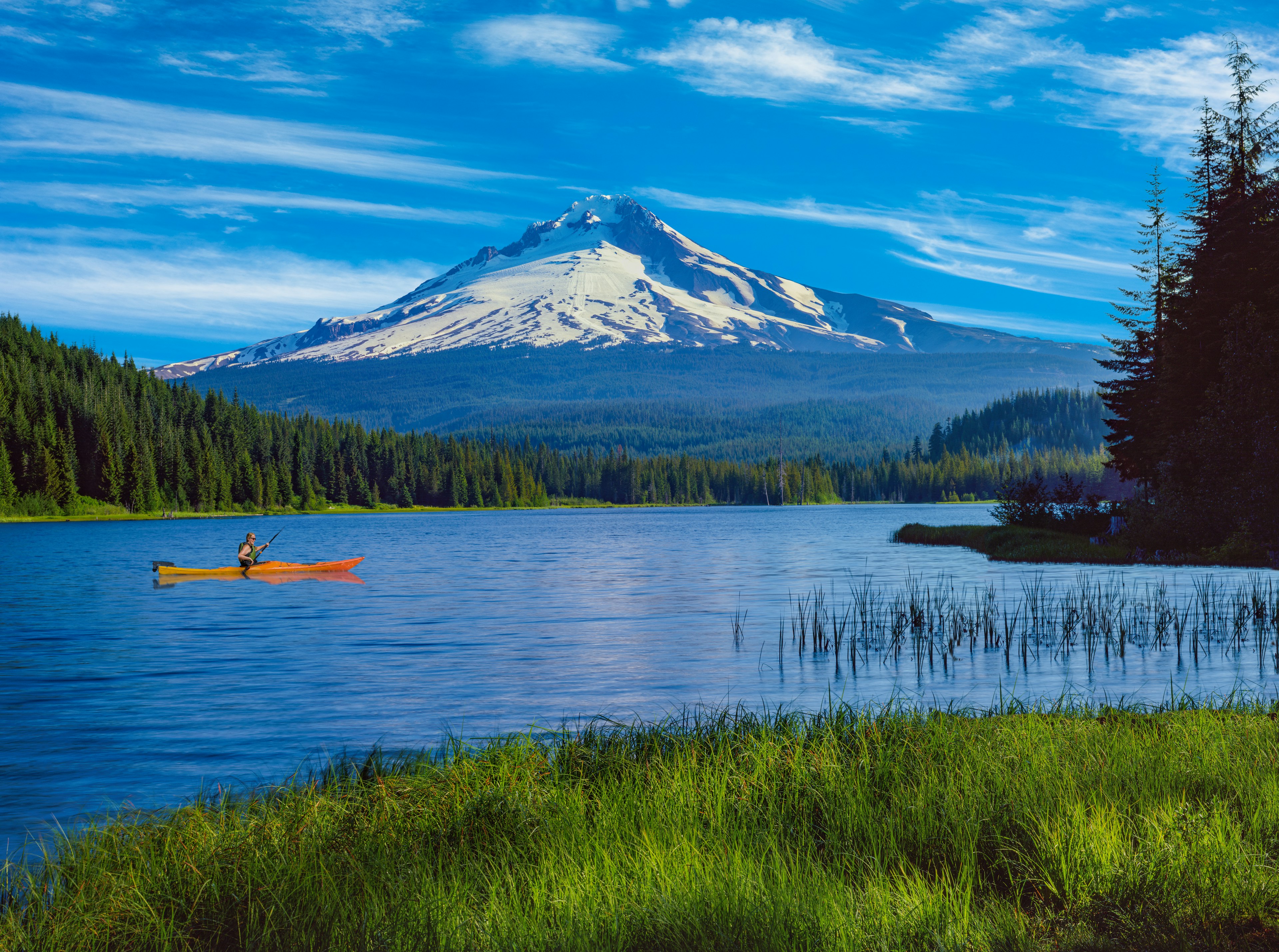 A kayaker on Trillium Lake with the reflection of Mt. Hood