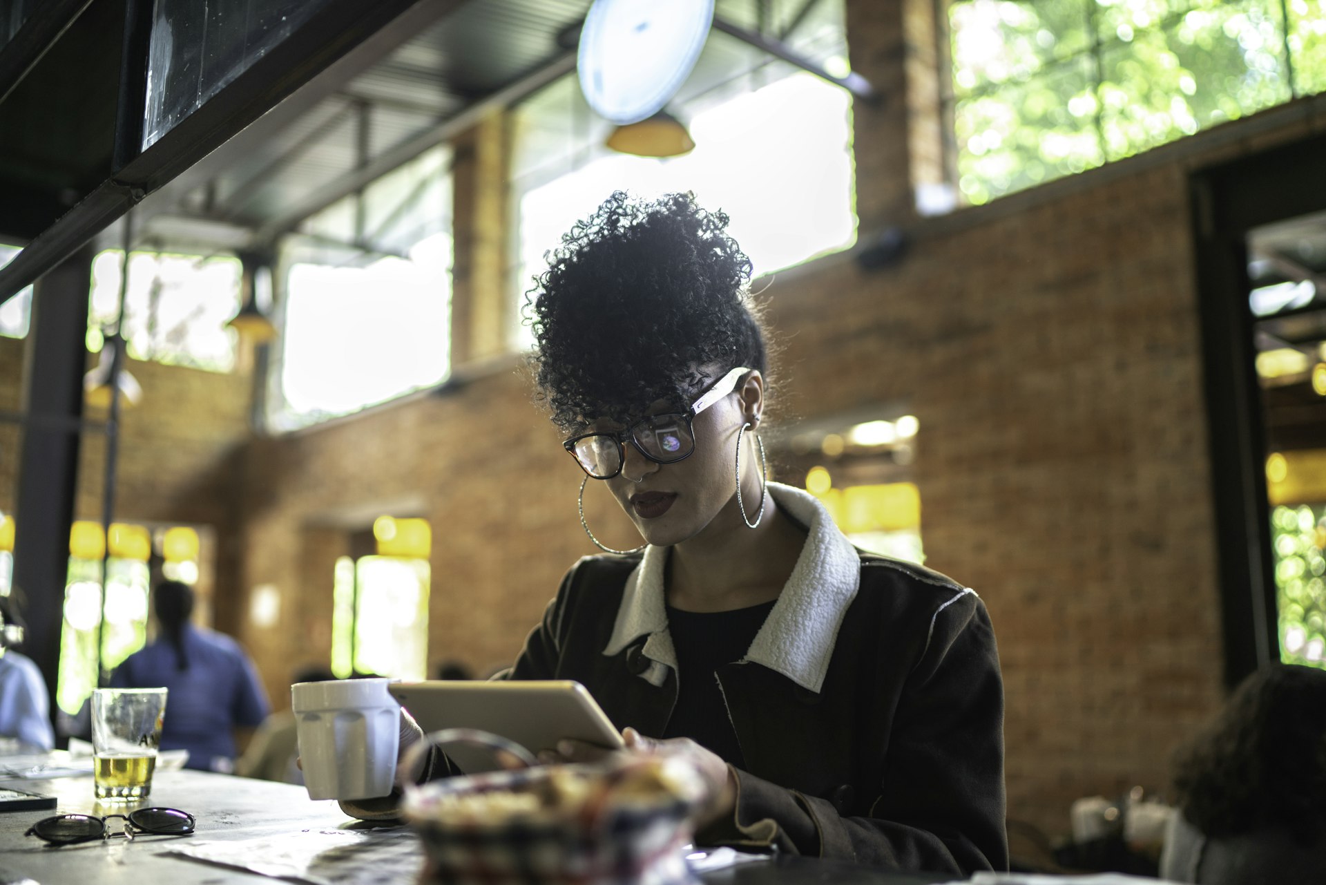 Woman reads on her tablet while dining alone at a restaurant