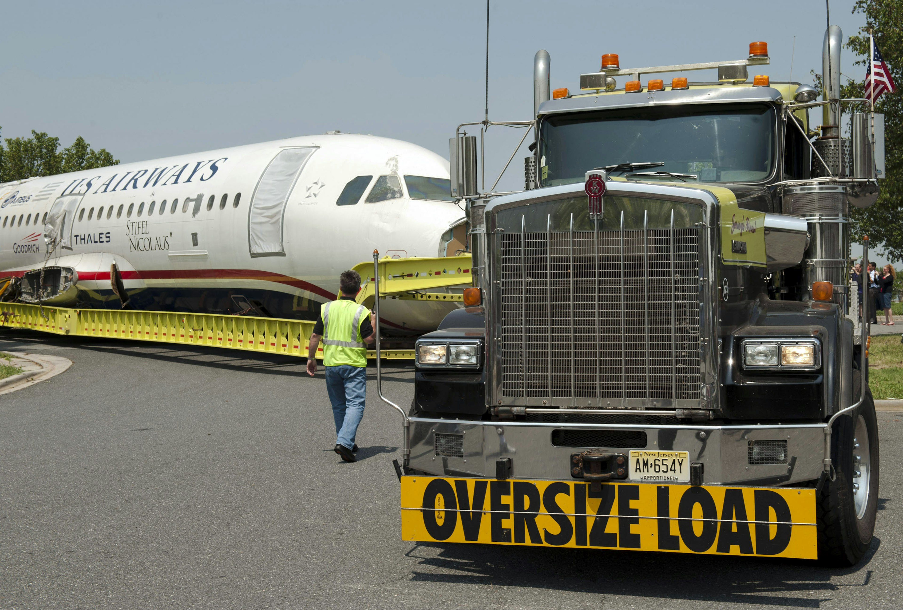 A plane on a massive truck as it is moved to a museum.