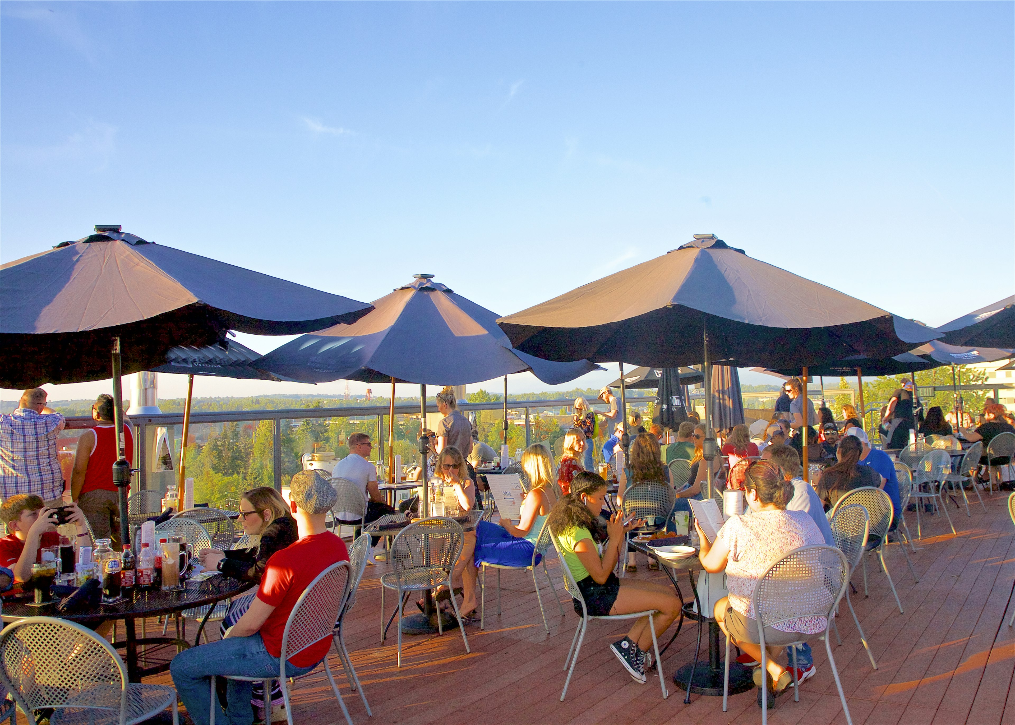 People on rooftop deck under sun umbrellas dining in Anchorage, Alaska, USA