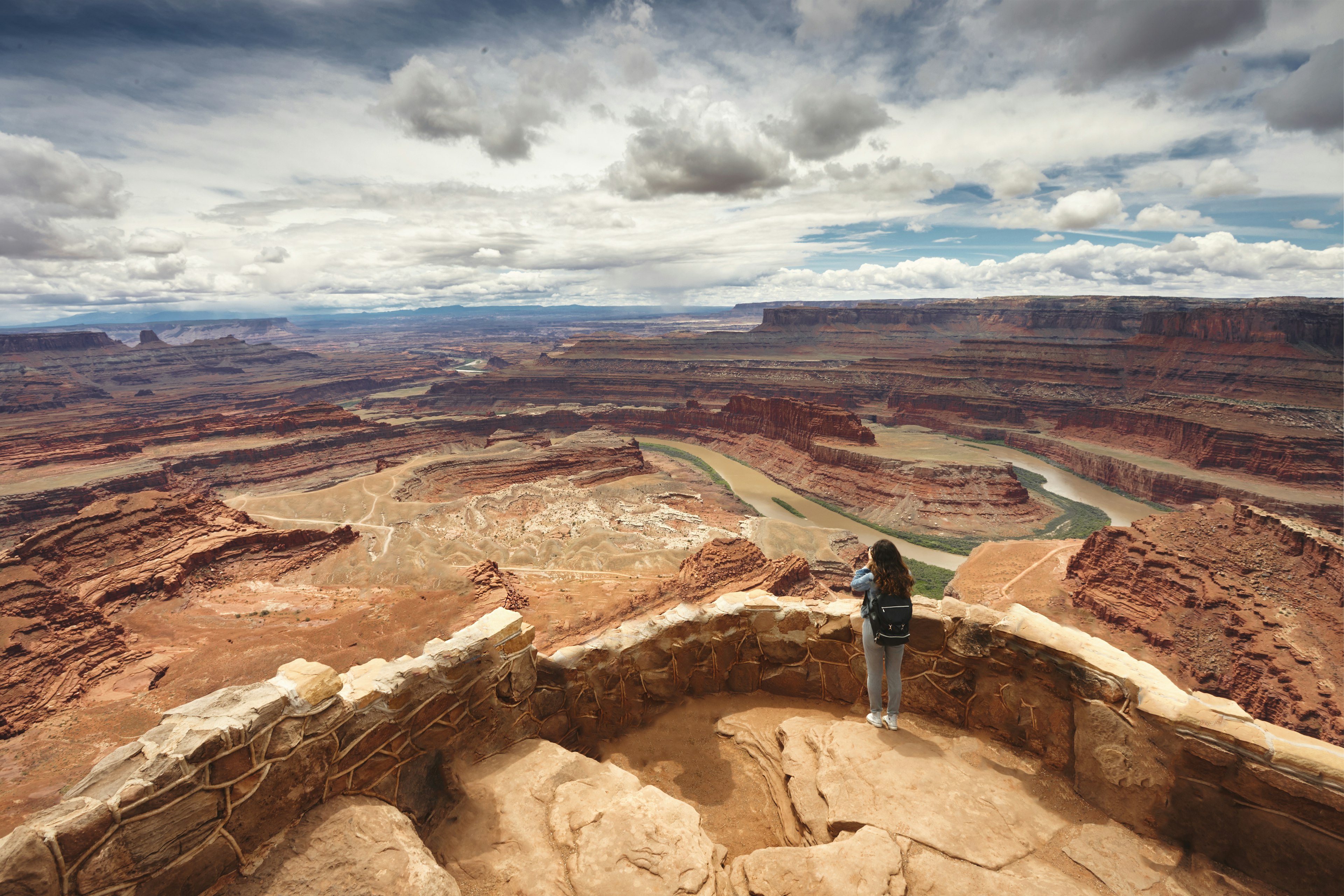 Женщина любуется видом с обрыва в Государственном парке Dead Horse Point, Юта
