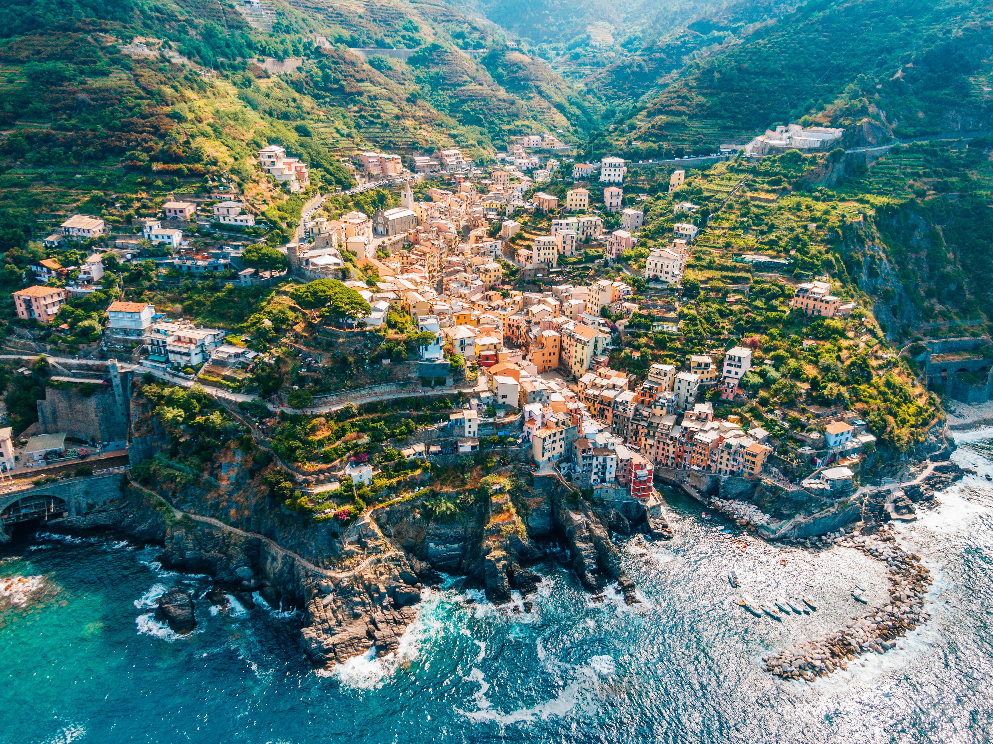 Town in mountains towering over tranquil sea in Cinque Terre.