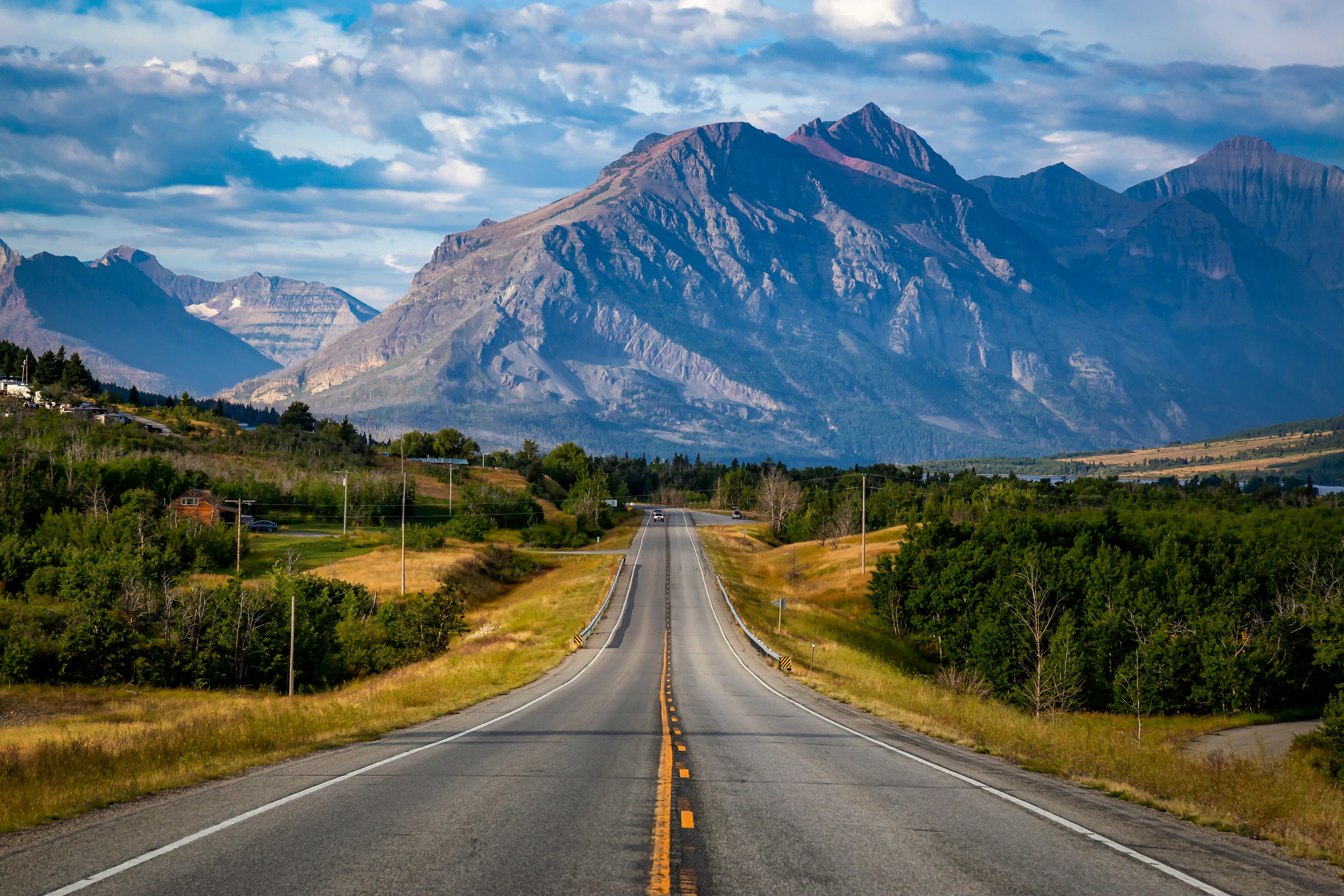 An empty road leading to mountains in Montana