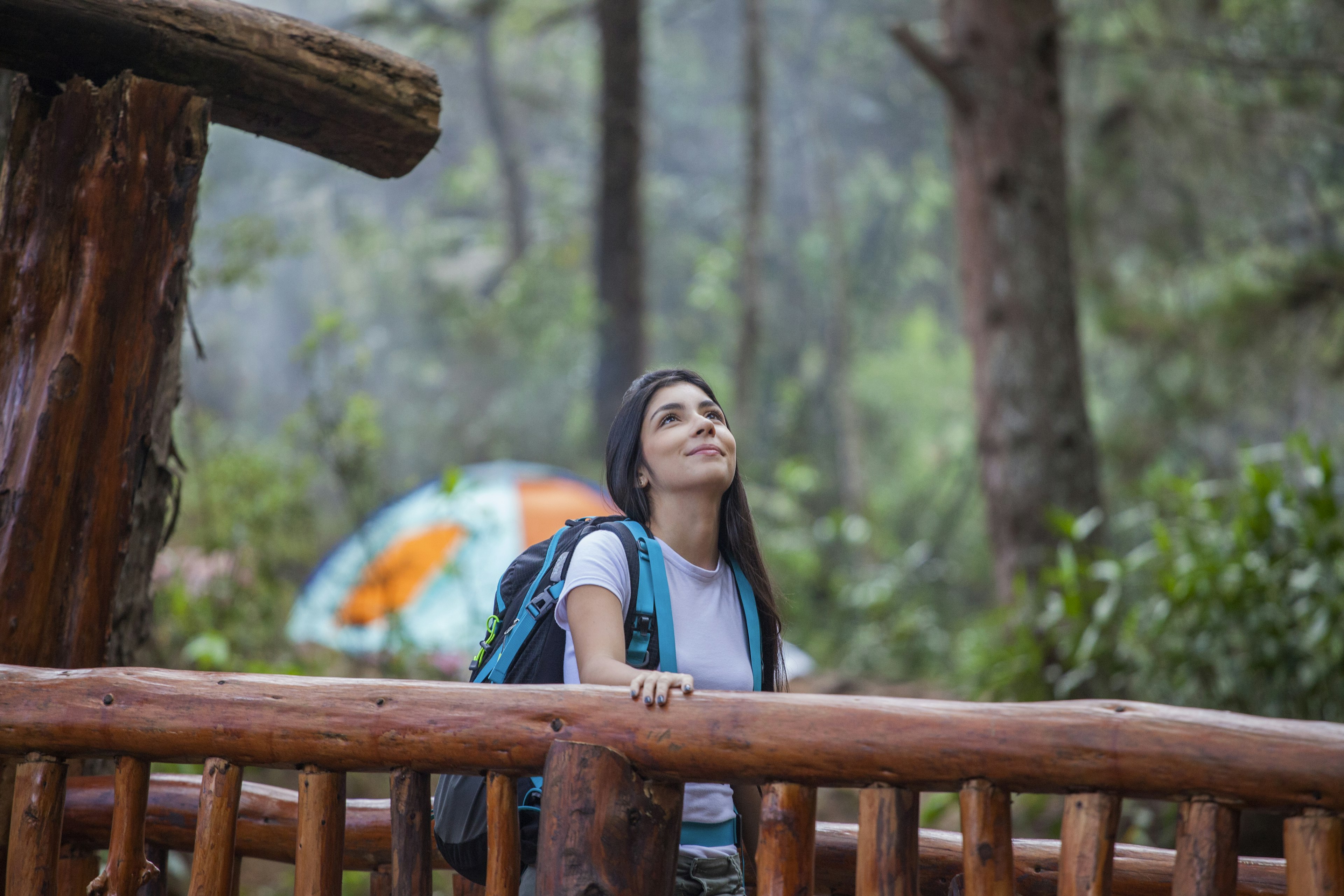 A woman walks over a wooden bridge in Parque Arví, Medellín