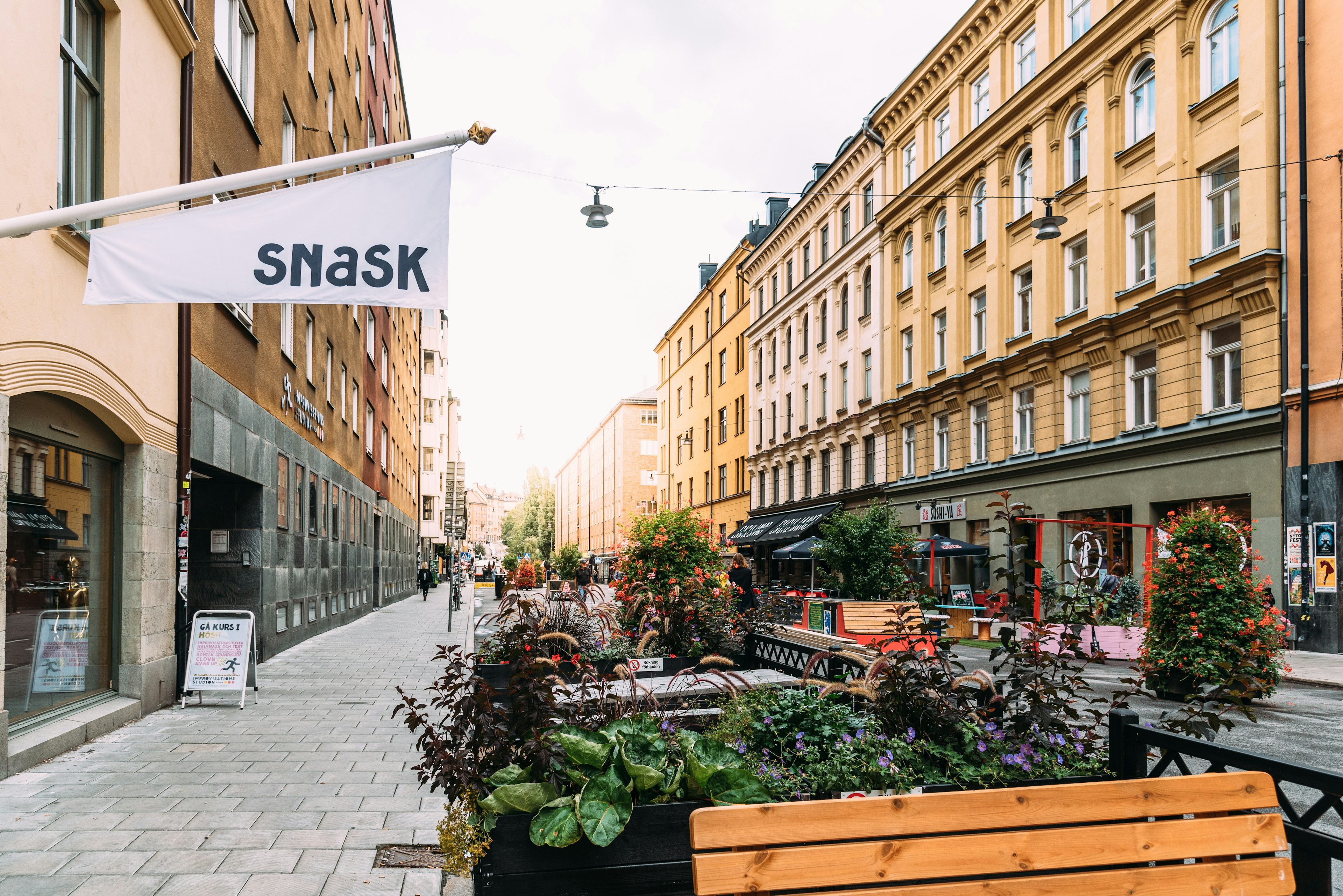 Shops and cafes line a street in a city