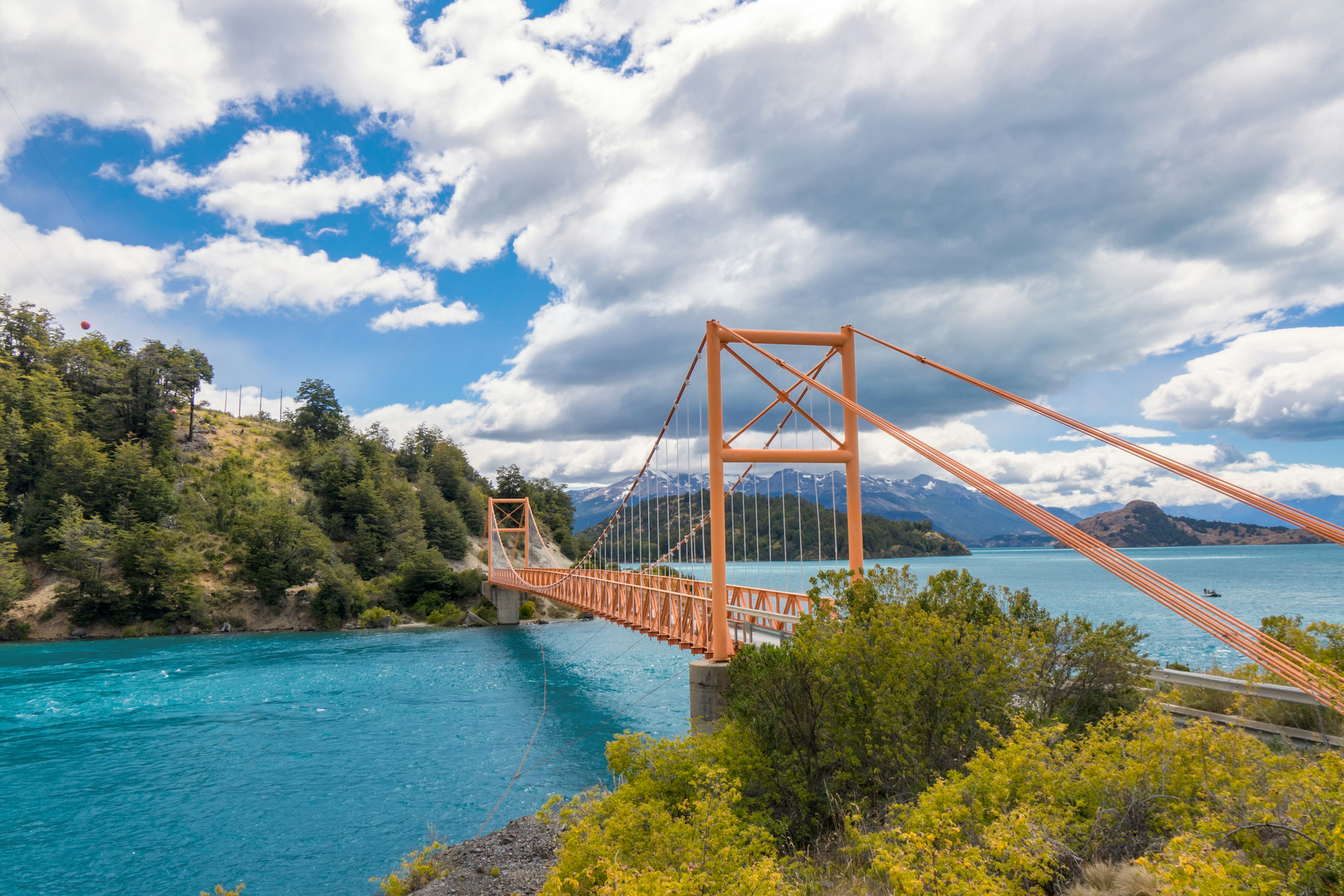 A short red road bridge over turquoise glacial lakes