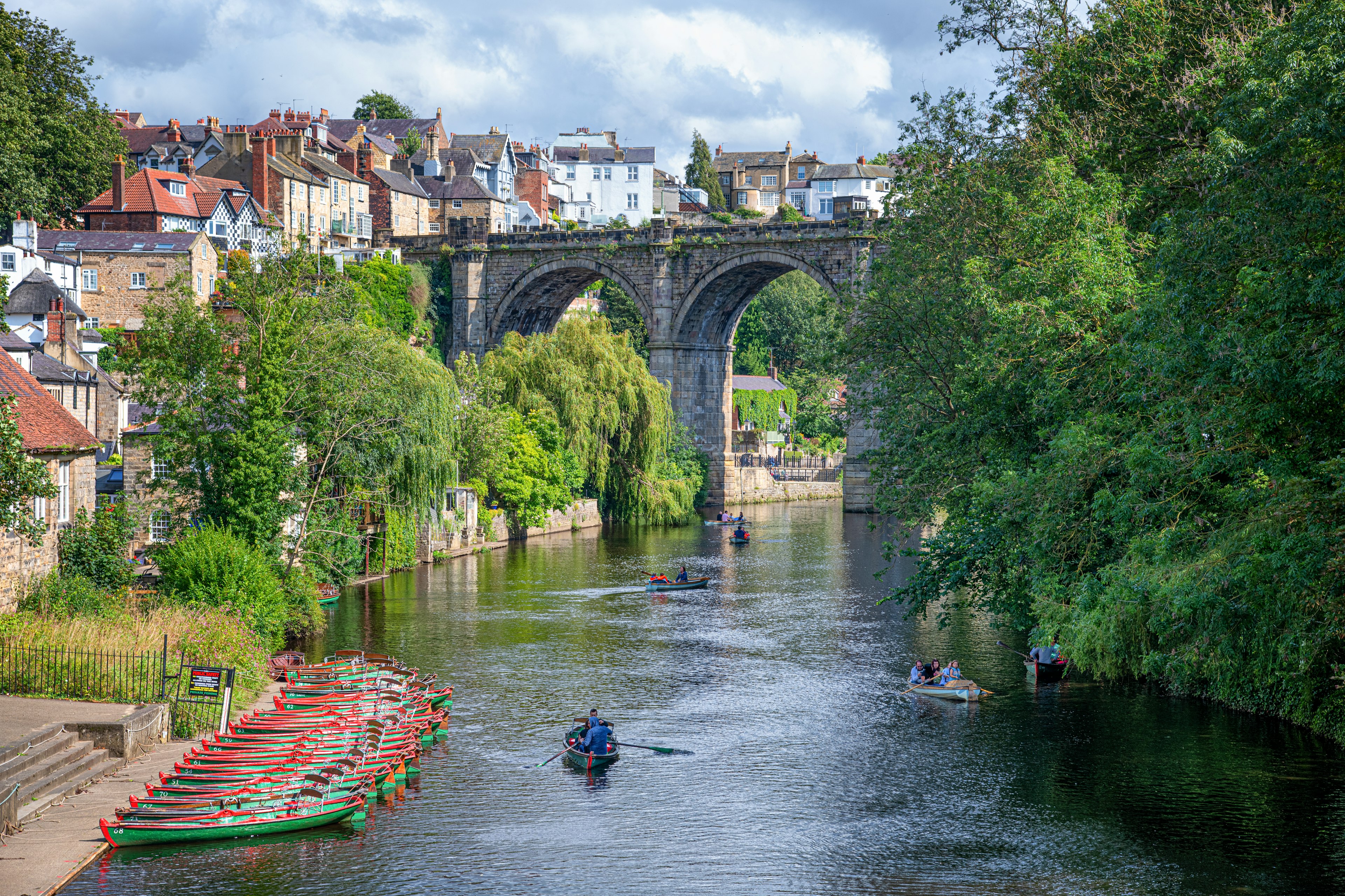 Rowing boats on the River Nidd in Knaresborough, with the famous railway train viaduct in the background