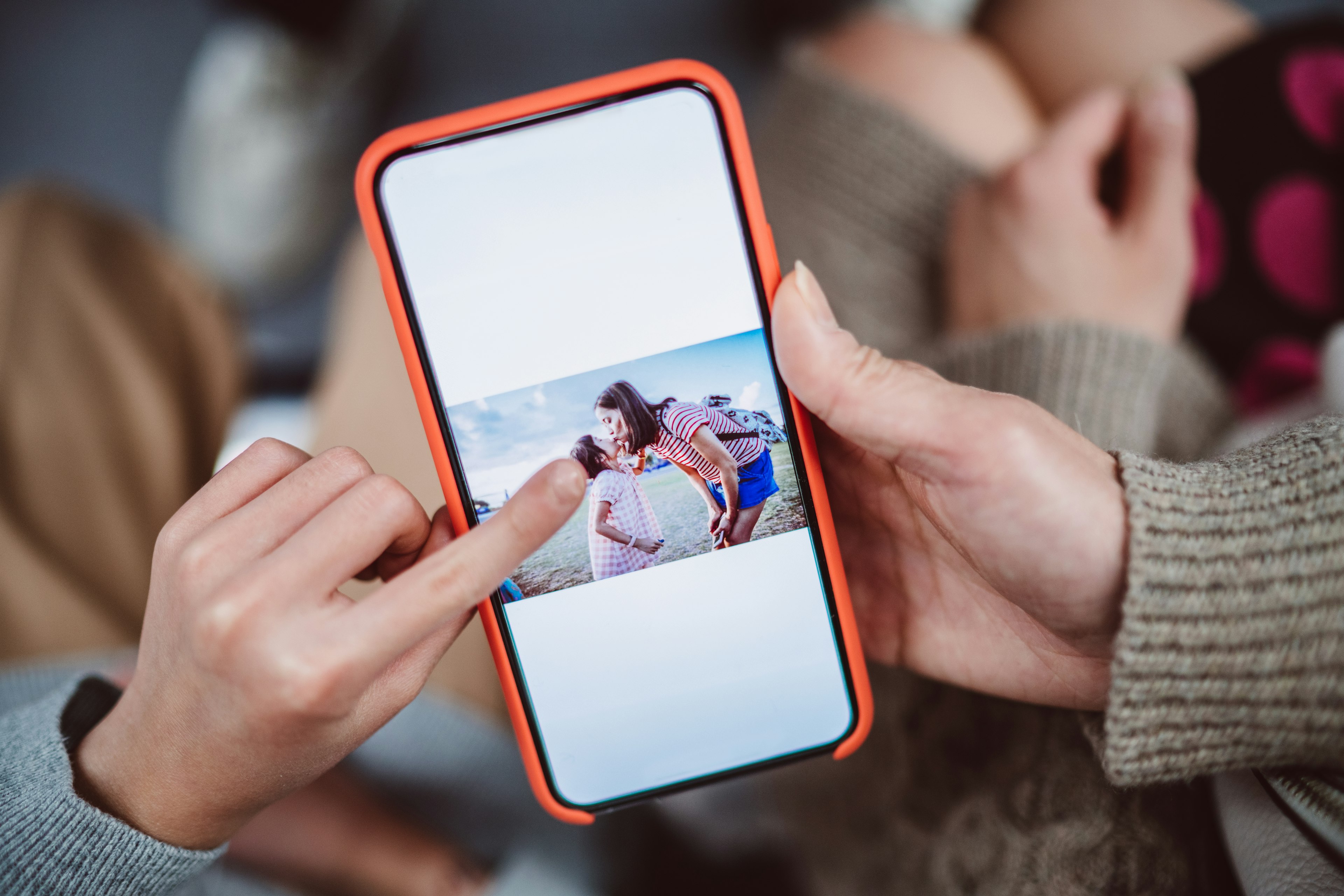 Close-up of mom & daughter's hands using smartphone together