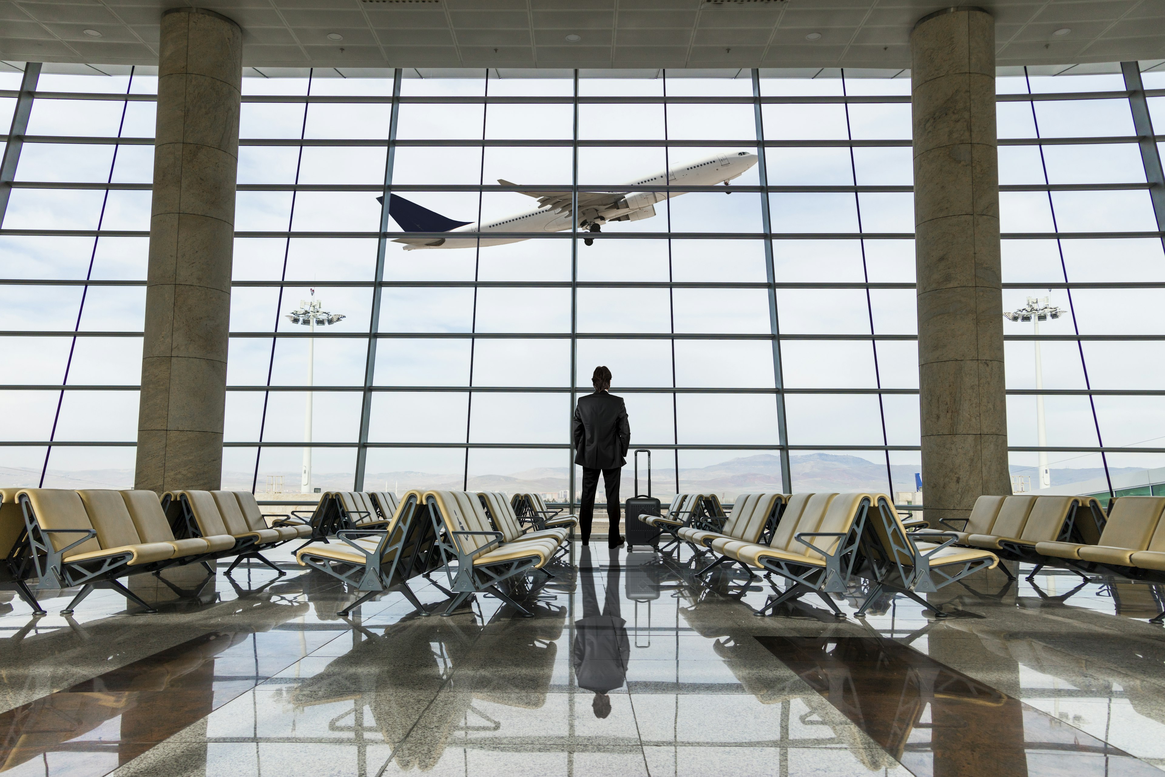 Businessman with luggage waiting in USA airport