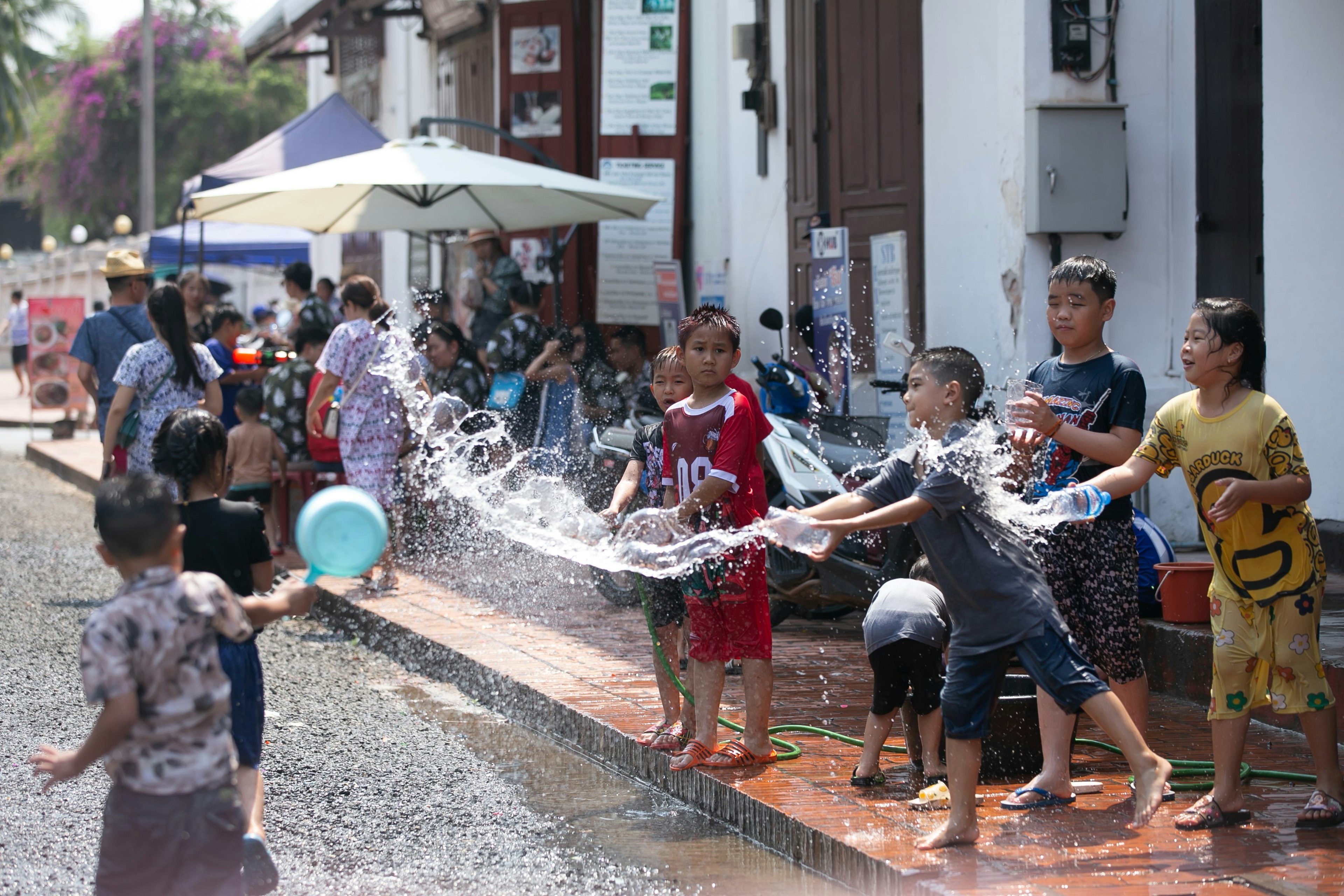 Boys sprinkle water on each other, celebrating Pi Mai (Lao New Year), Luang Prabang, Laos