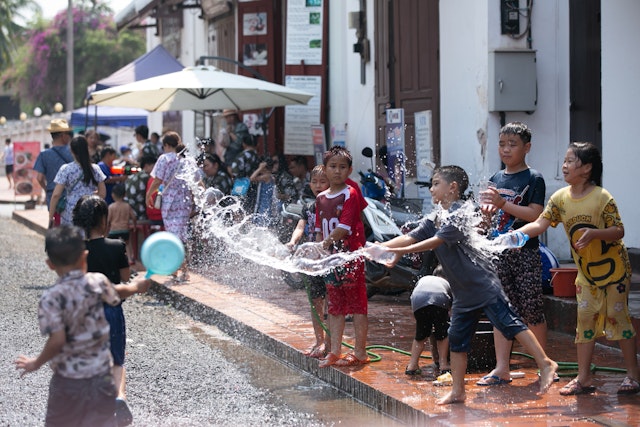 Boys sprinkle water on each other, celebrating Pi Mai (Lao New Year), Luang Prabang, Laos