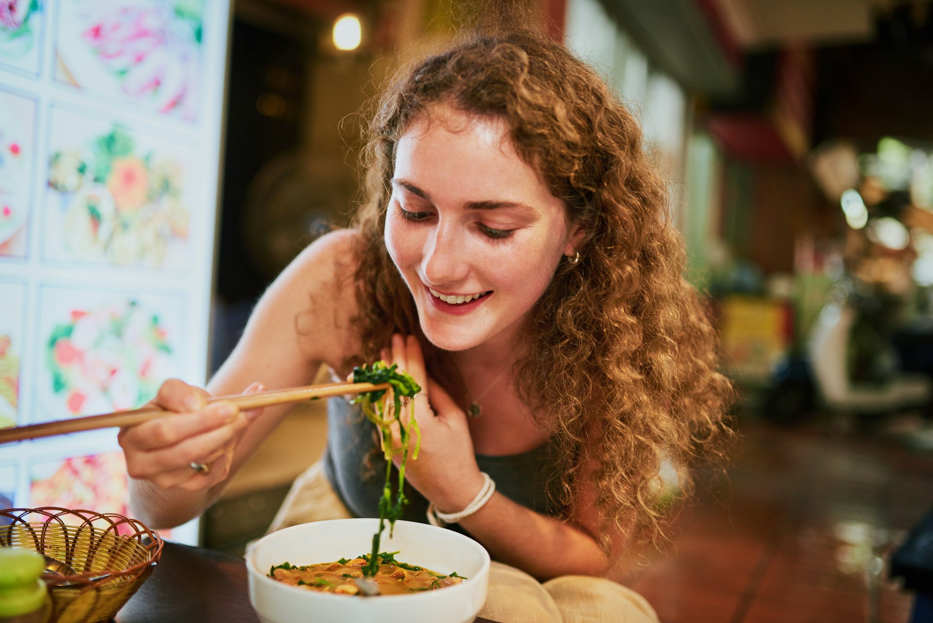 Woman eats noodles at a restaurant 