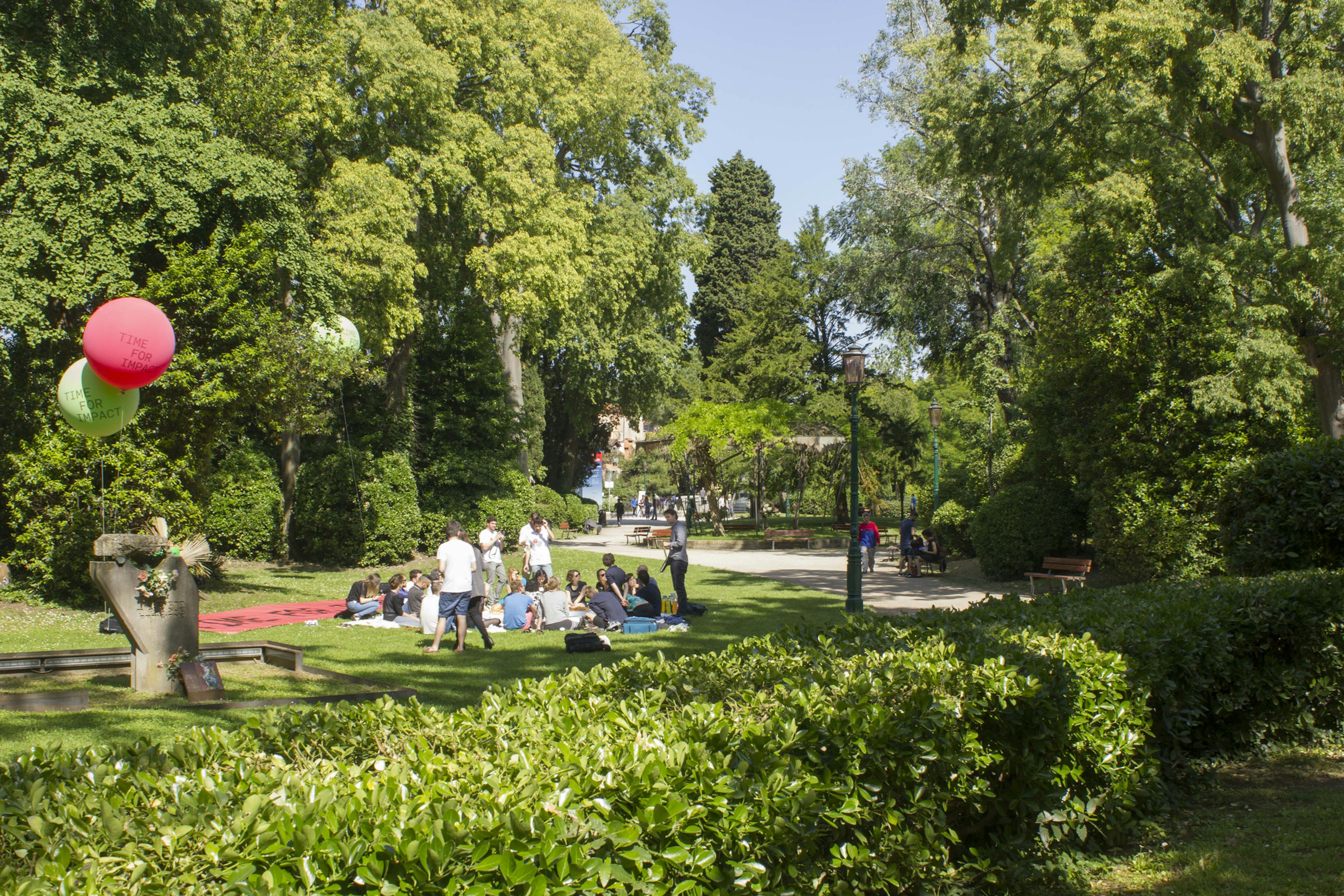 Group of people seat on the Giardini della Biennale publick park in venice, Italy