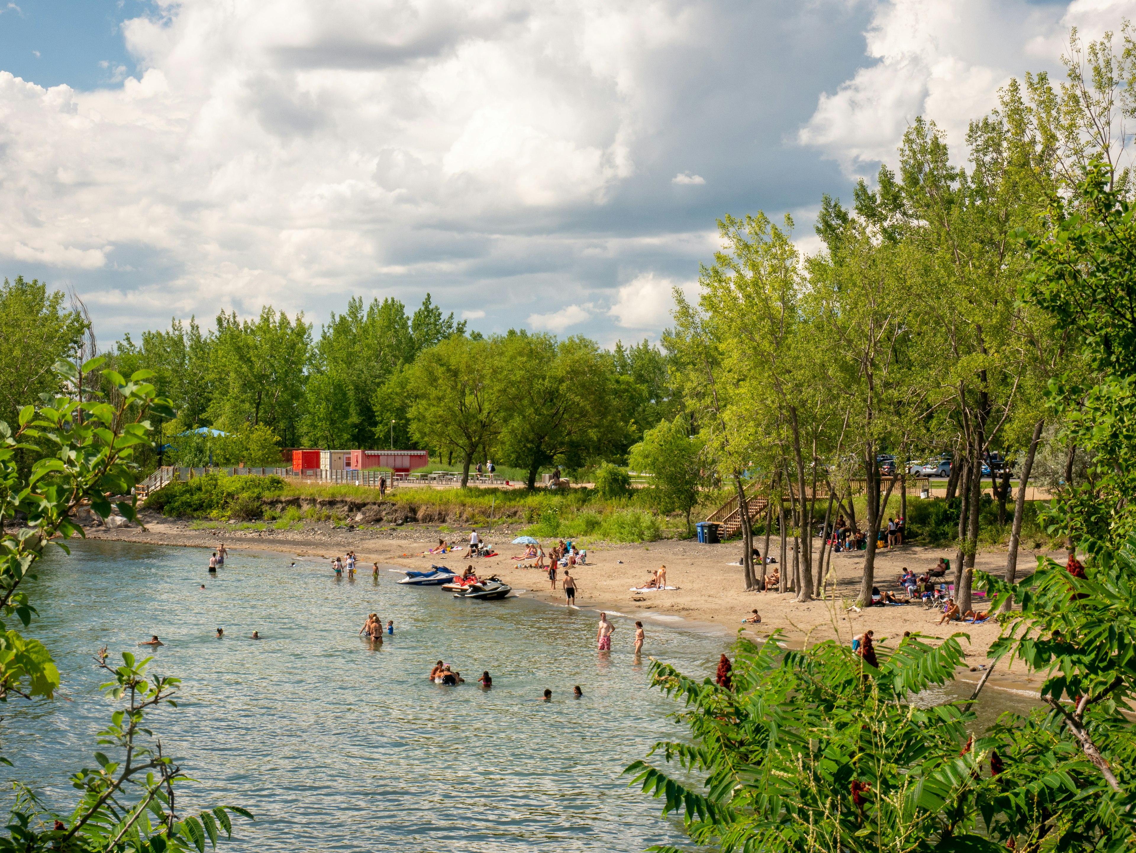 People in the sun on a river beach near Montreal