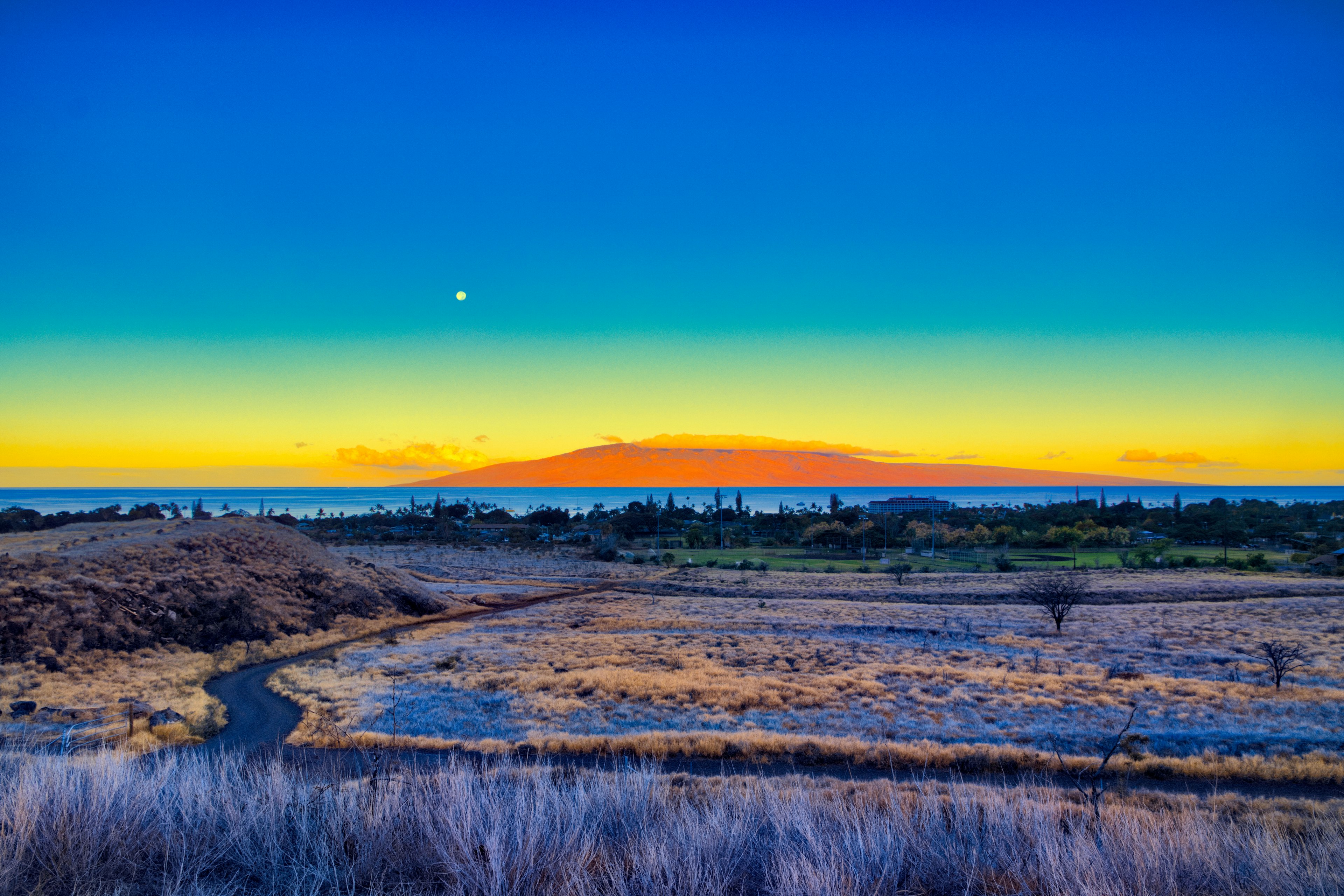 Surrealistic moonset over Lahaina on Maui with Lanai in the distance.