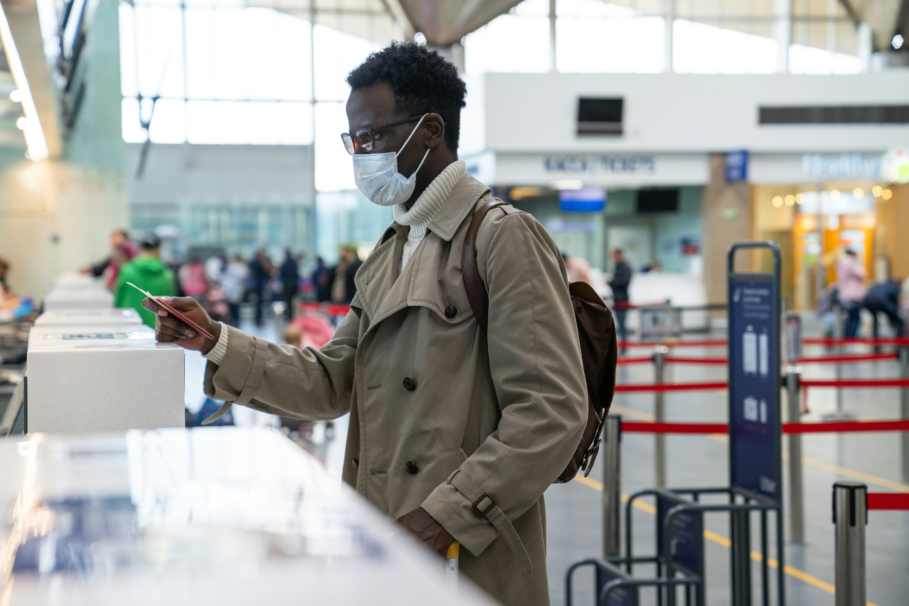 Young Man Wearing Mask Standing At Airport