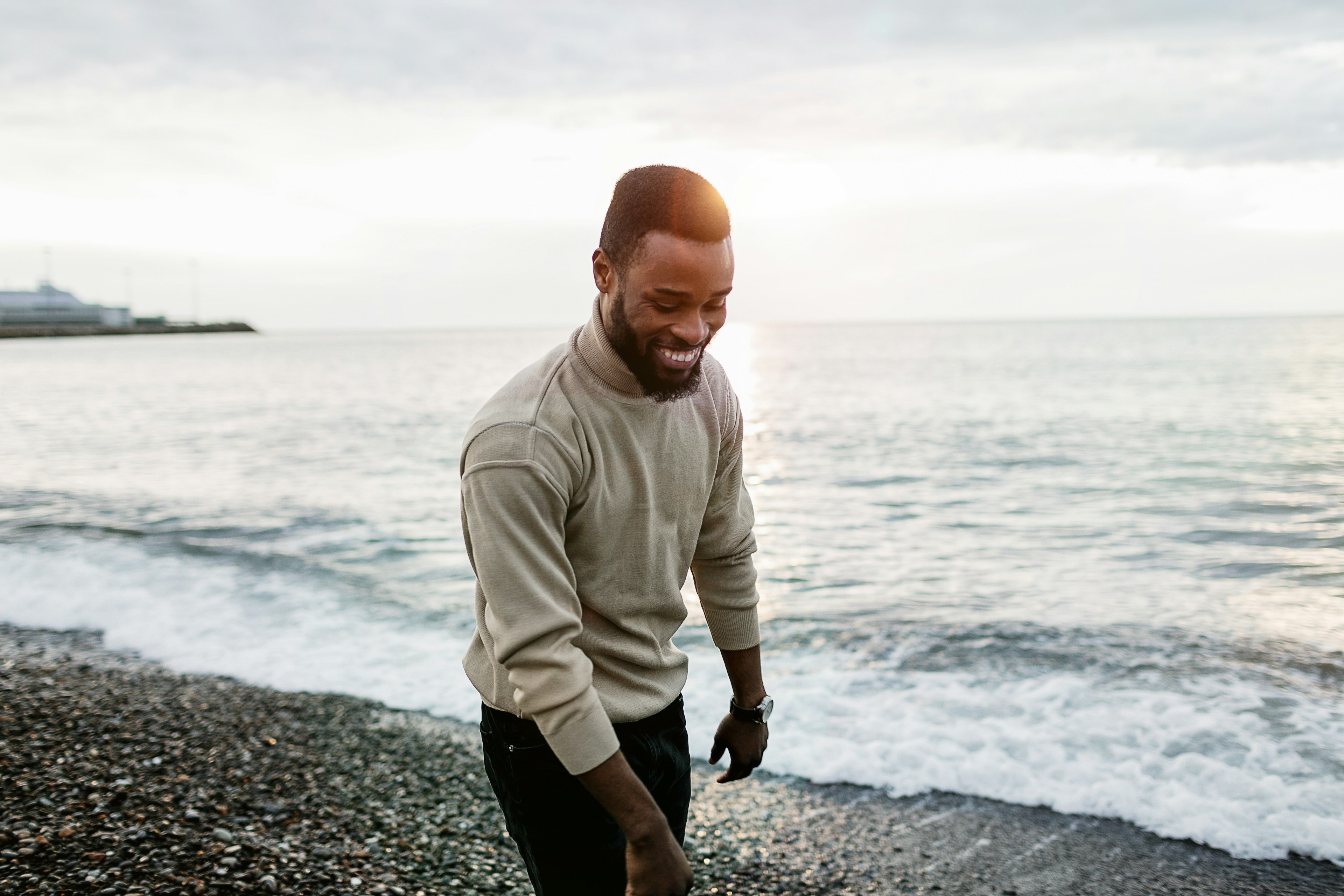 A young, happy Black man on the beach