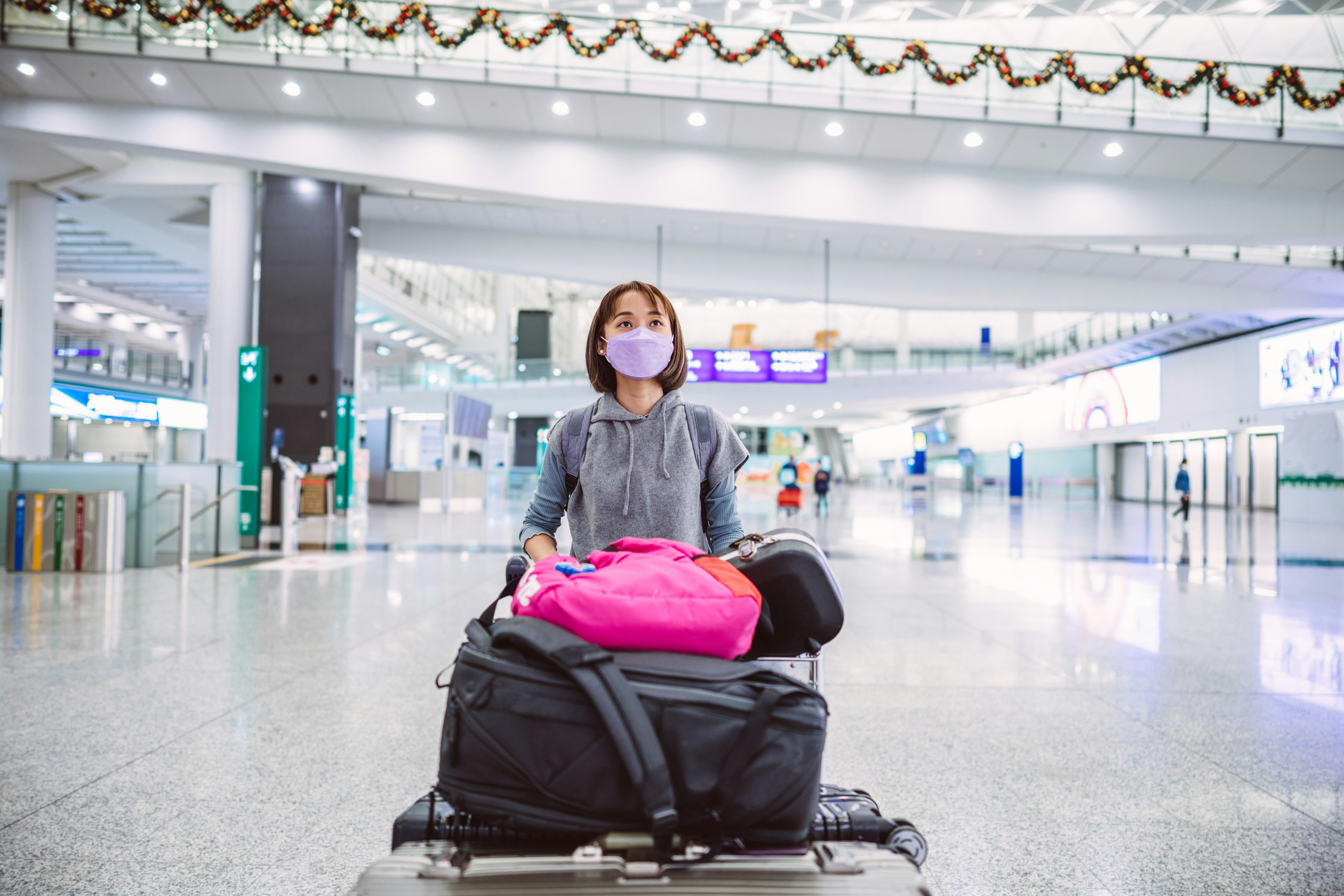 A young woman wearing a protective face mask in an airport