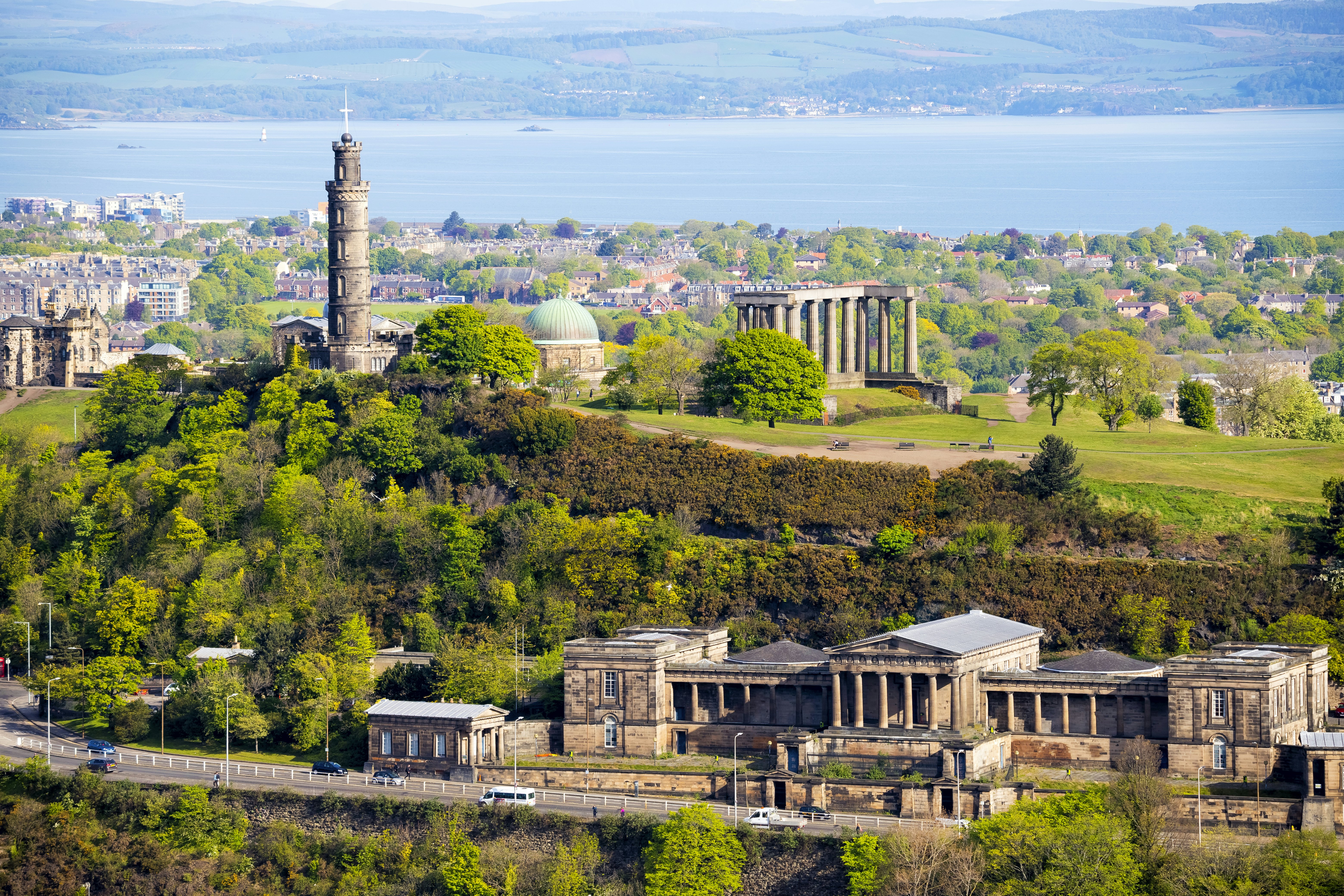 Open parkland with several significant stone monuments, and a large body of water in the distance