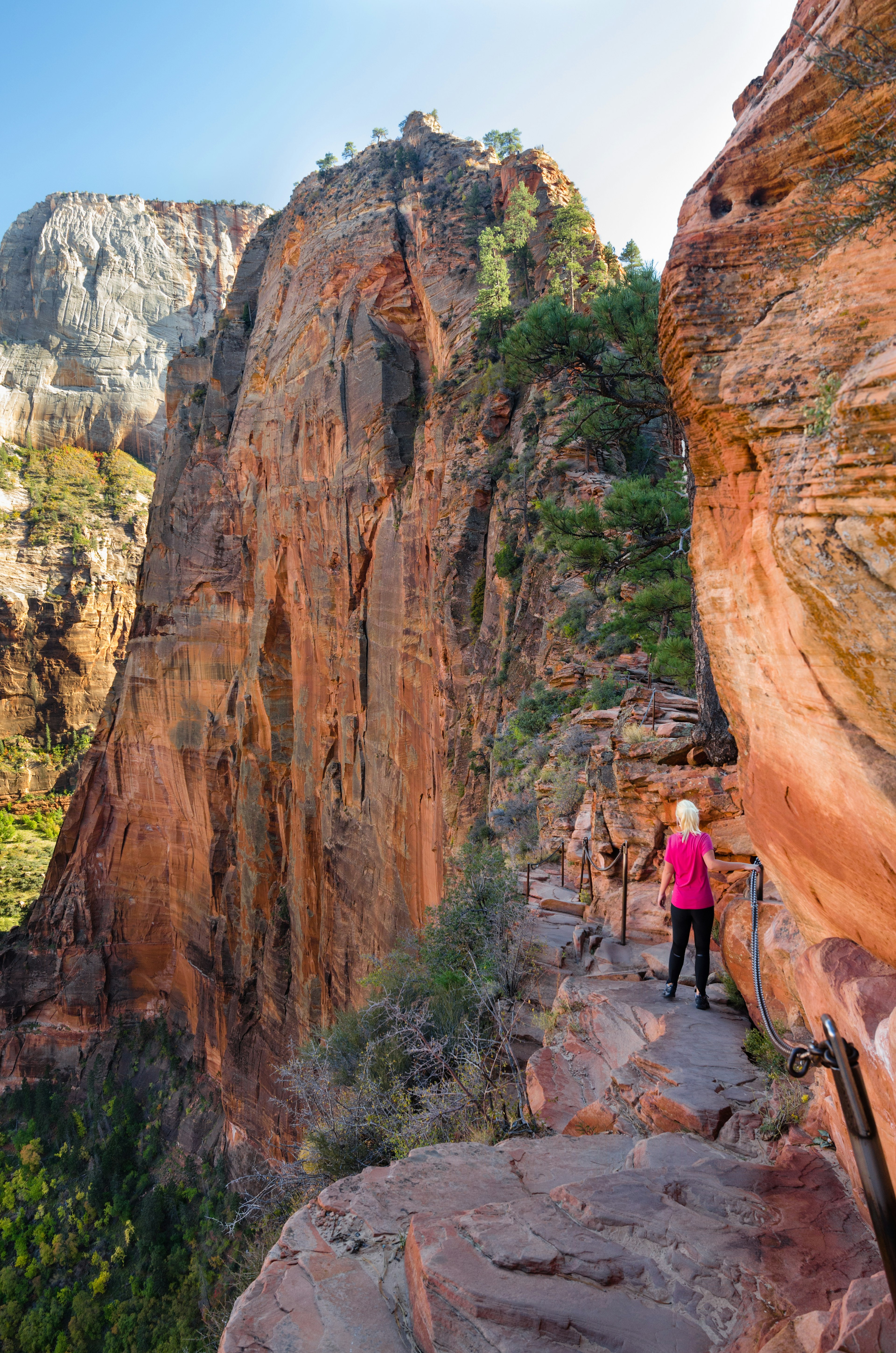 A woman hikes along a high path in Utah.