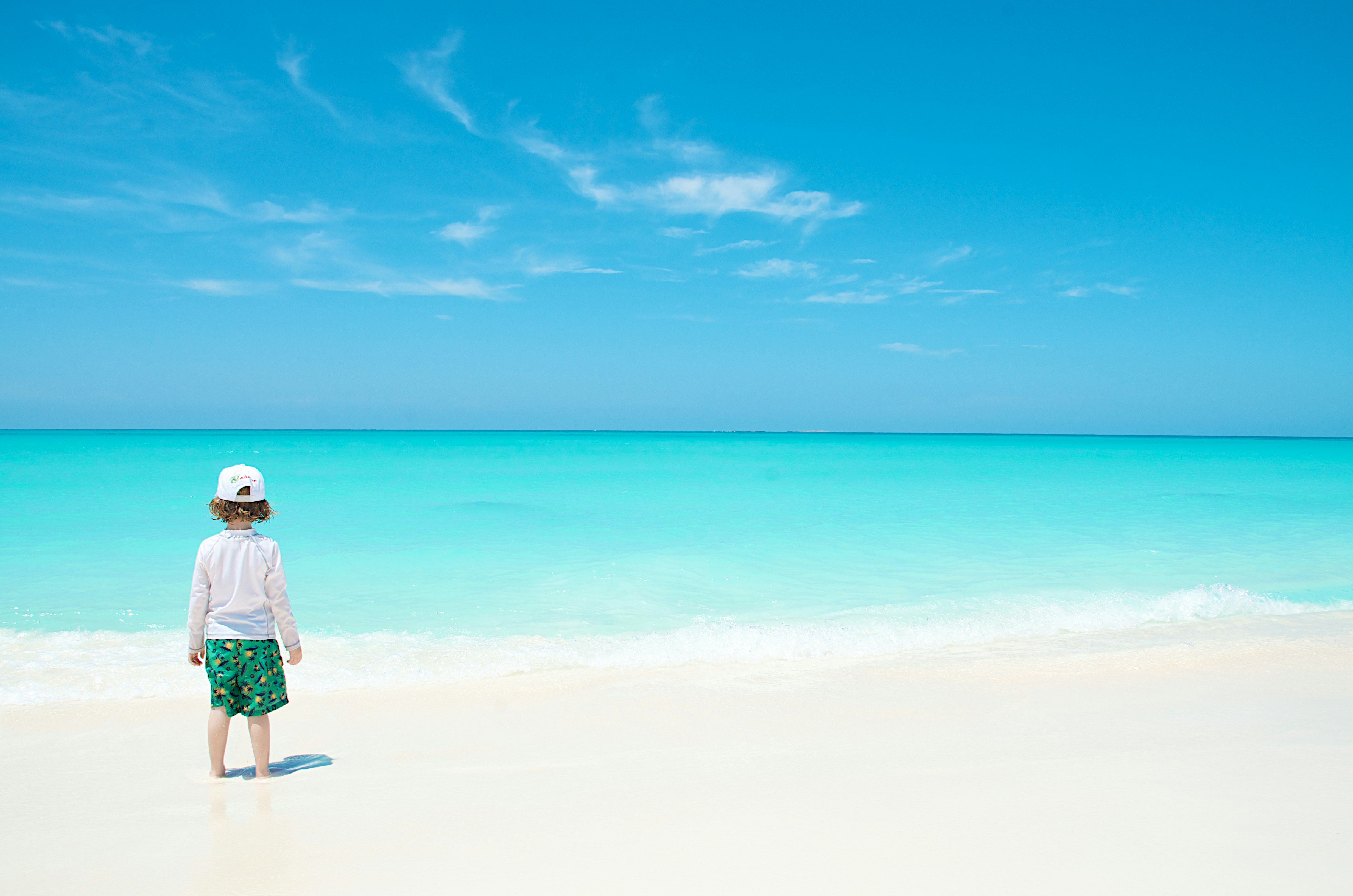 A child looking out to sea at Playa Paraiso, Cayo Largo, Cuba