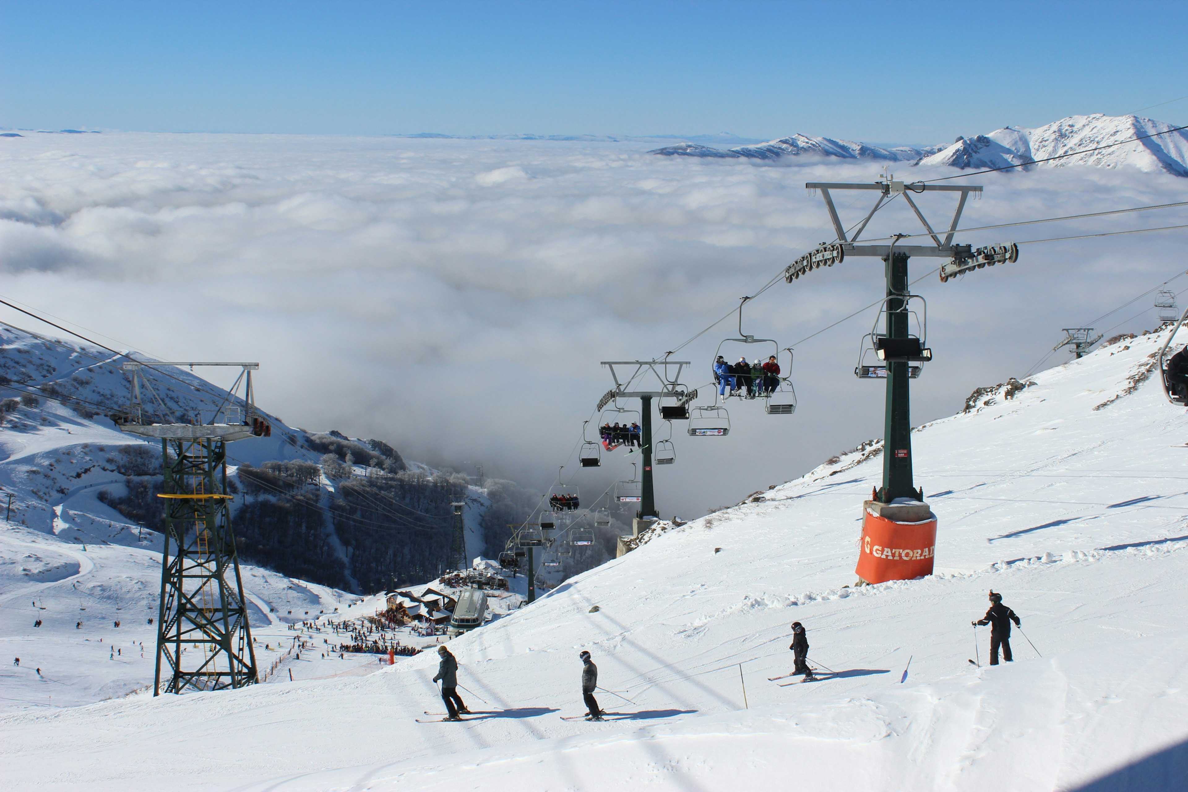 People skiing above the clouds at a ski station