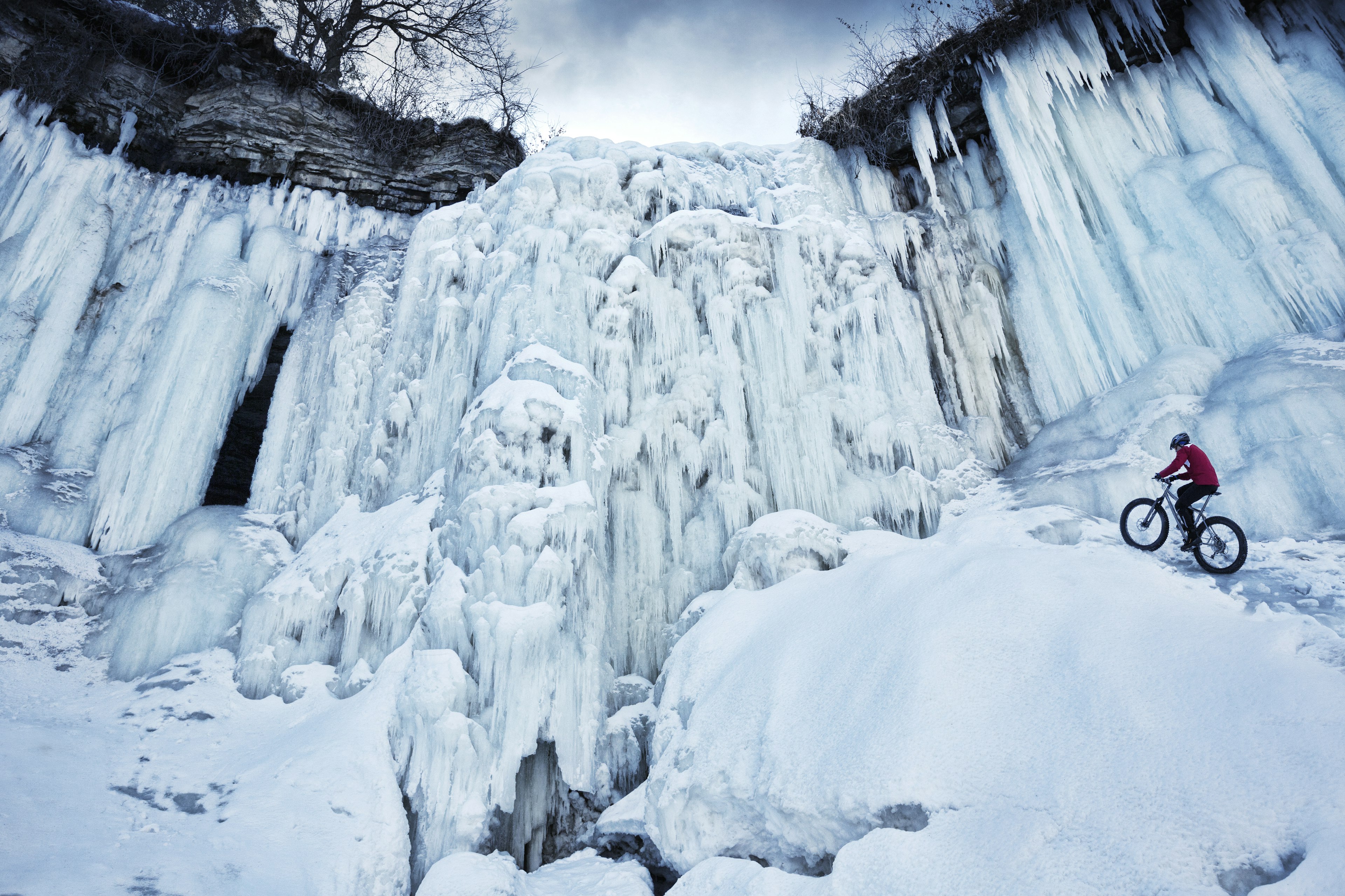 A bike rider climbing up the frozen Minnehaha waterfall in Minneapolis