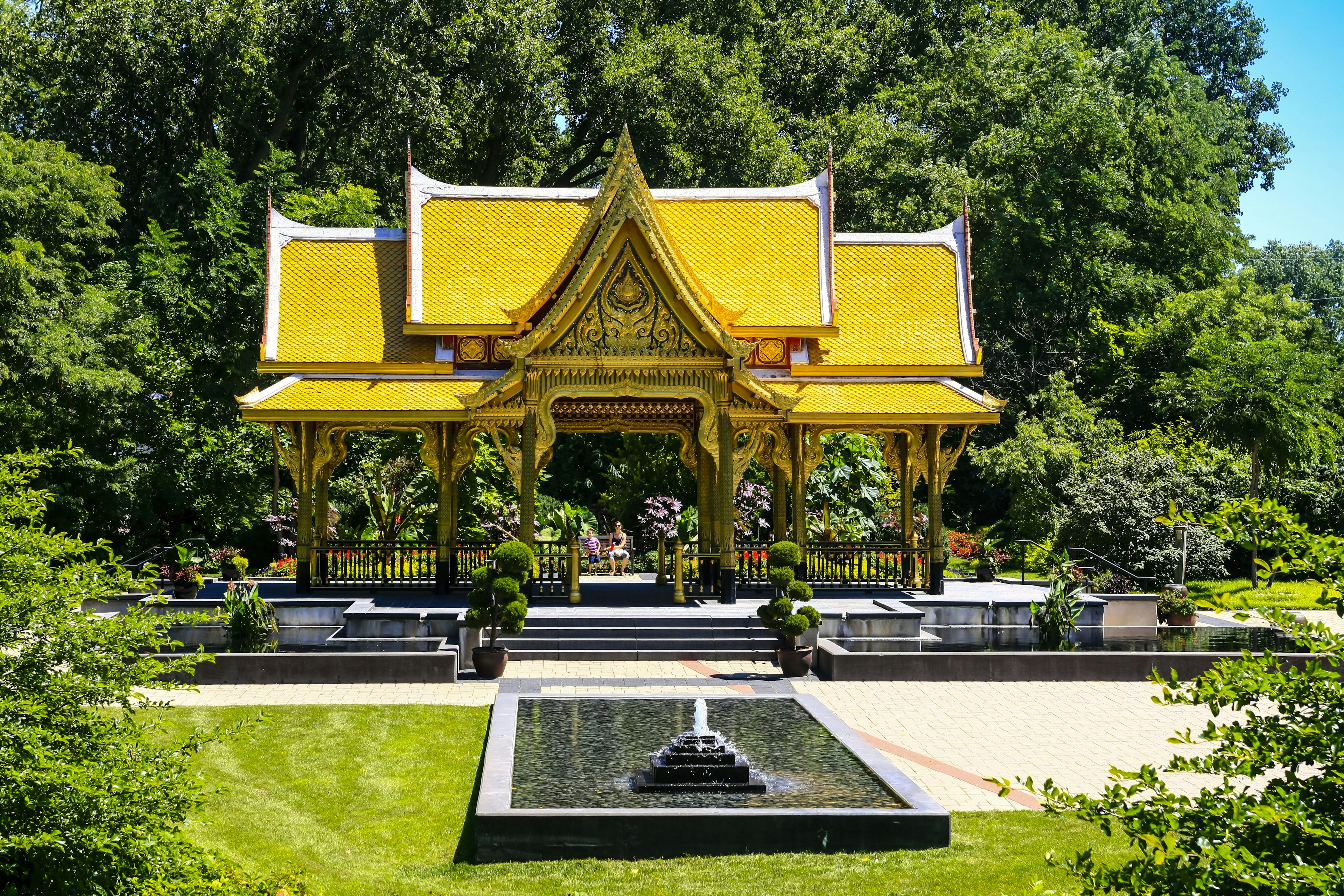 The golden, pagoda-like roof of the Thai Pavilion seen among ornamental plantings at Olbrich Botanical Gardens