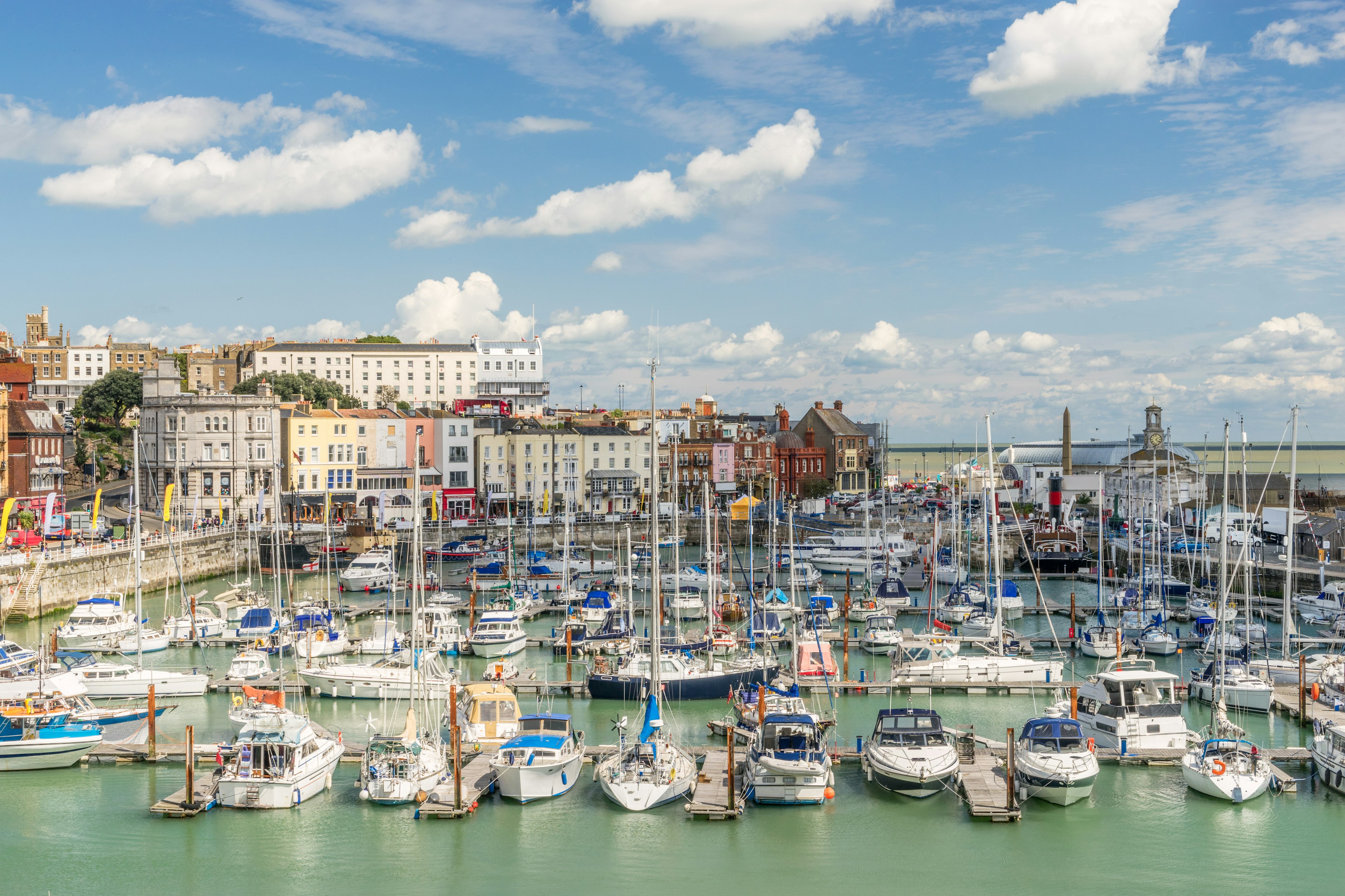 A pretty harbor docked with many small sail boats