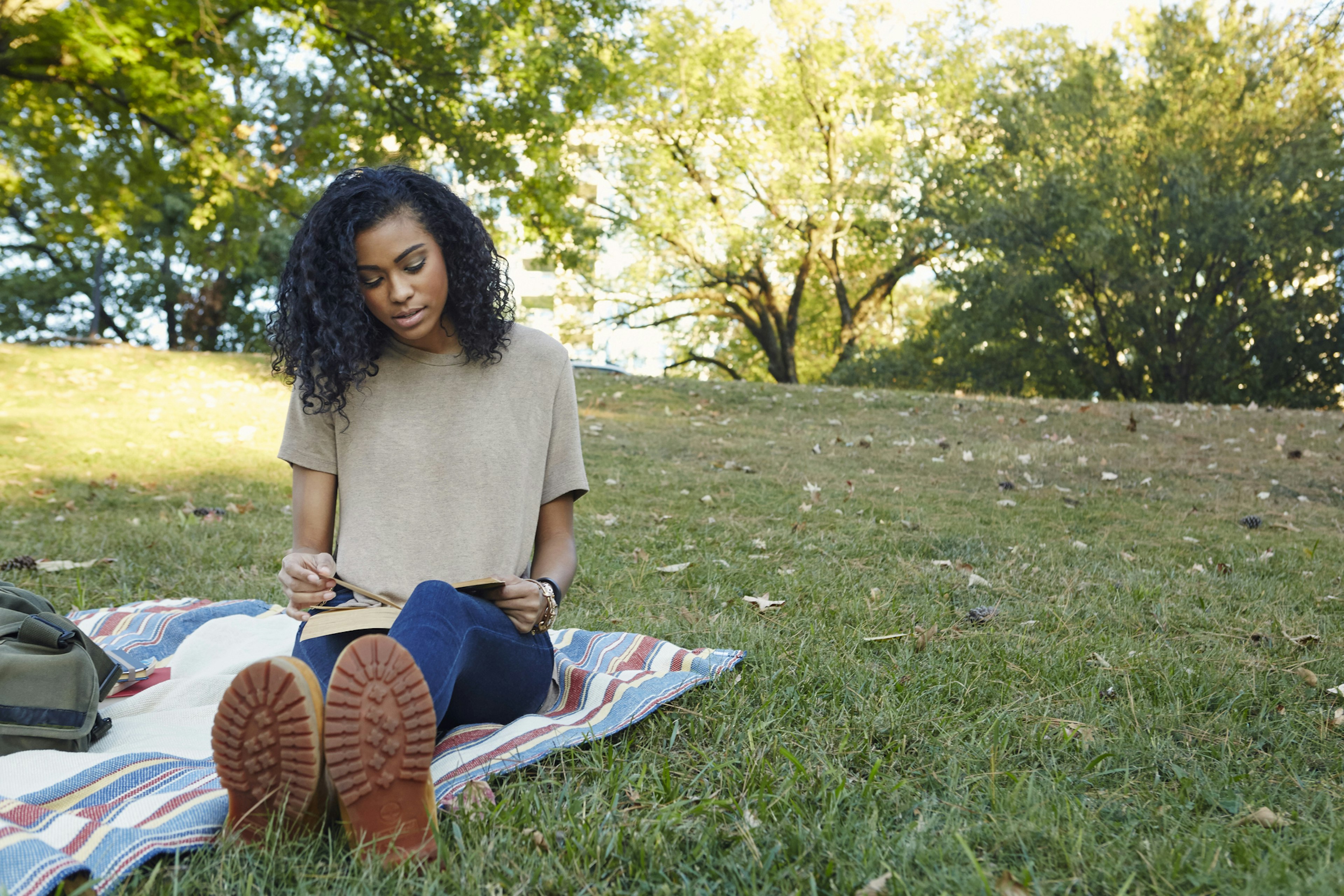 College Student reading in a city park