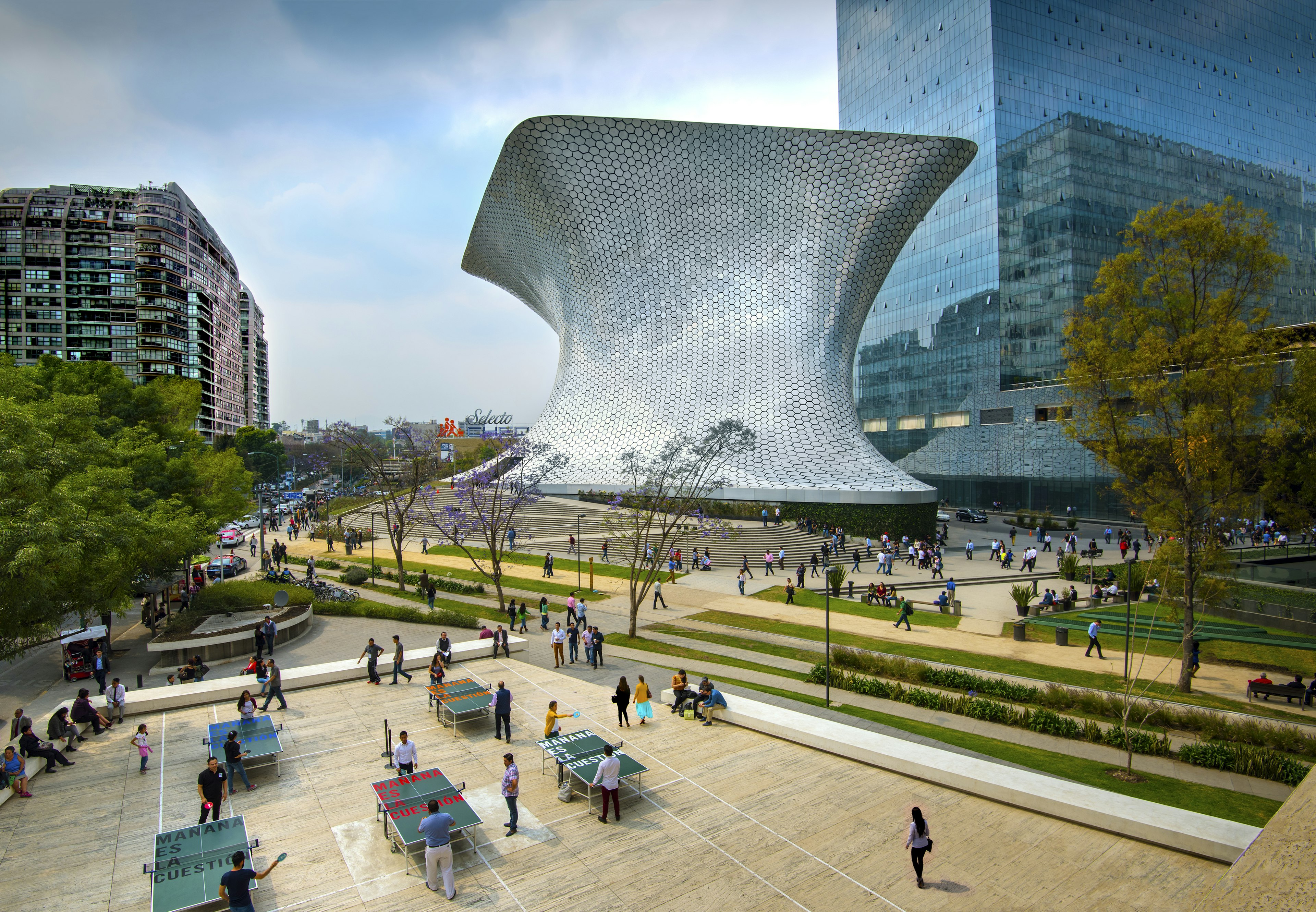 An overhead shot of workers on their lunch break enjoying a game of ping pong in front of the shiny, aluminum-paneled Soumaya Museum in Plaza Carso in the Polanco district of Mexico City.