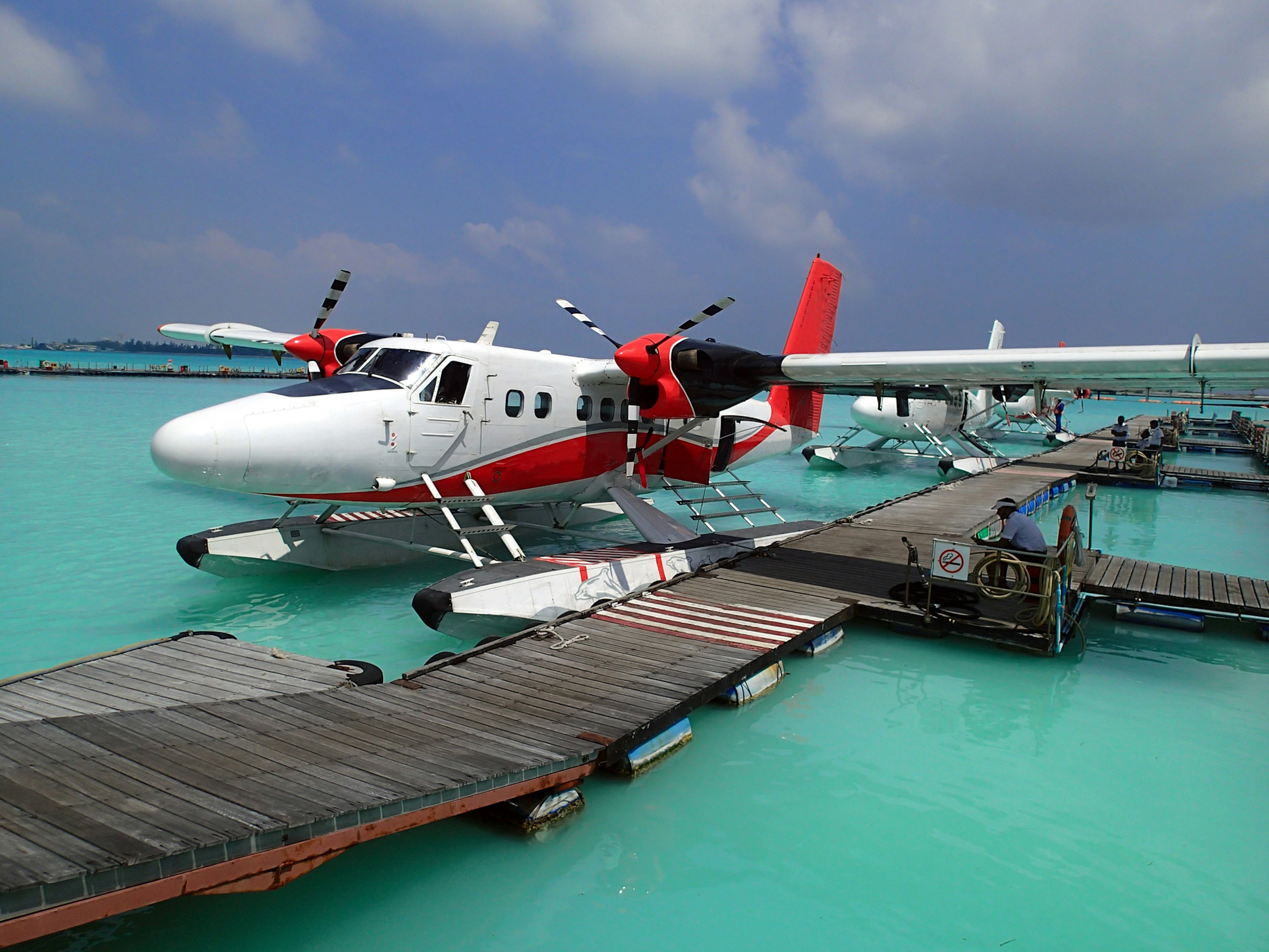 A small seaplane beside a wooden dock