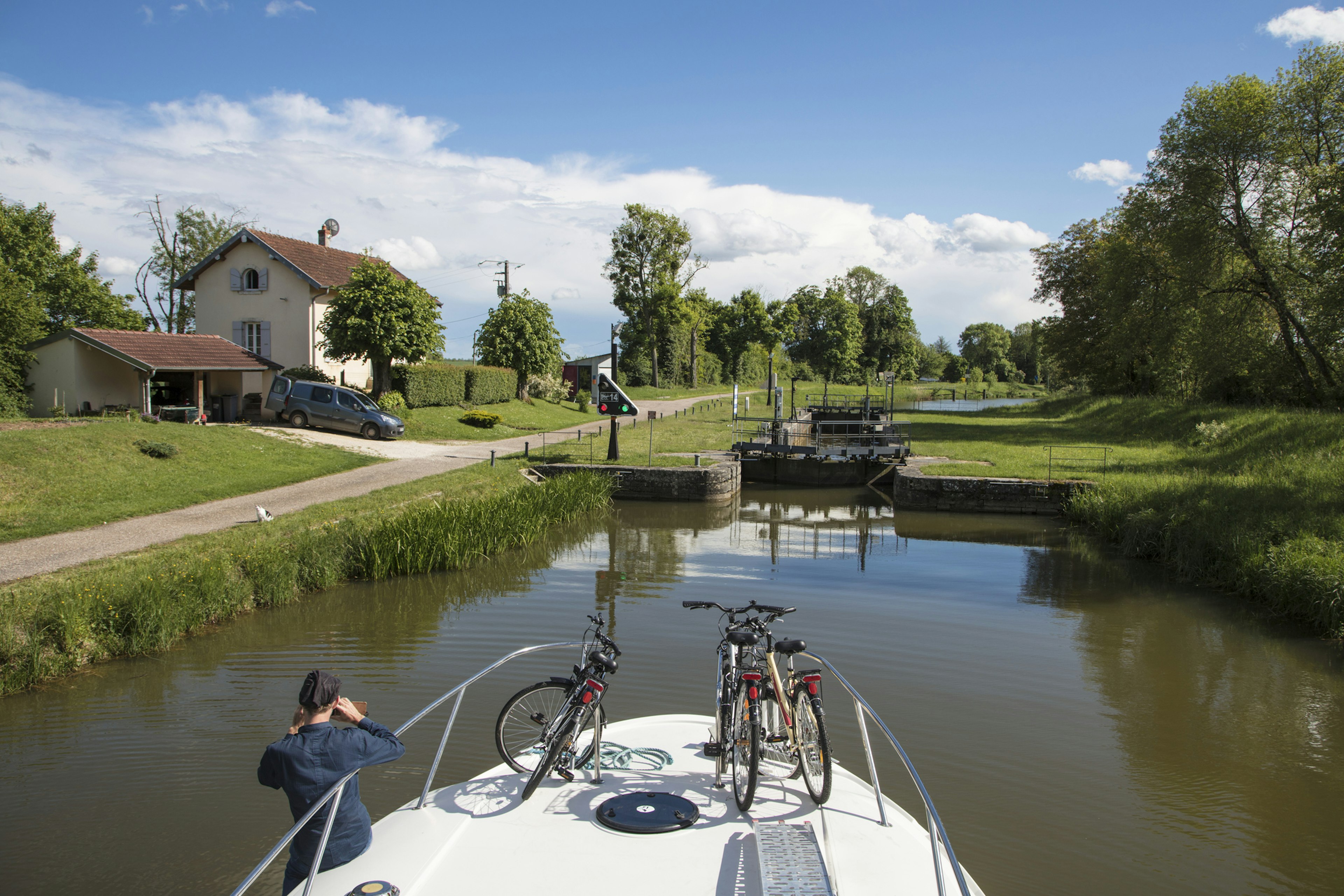 Houseboat approaches a lock during a cruise on the Petit Saone river, Haute-Saone, Bourgogne Franche-Comte France