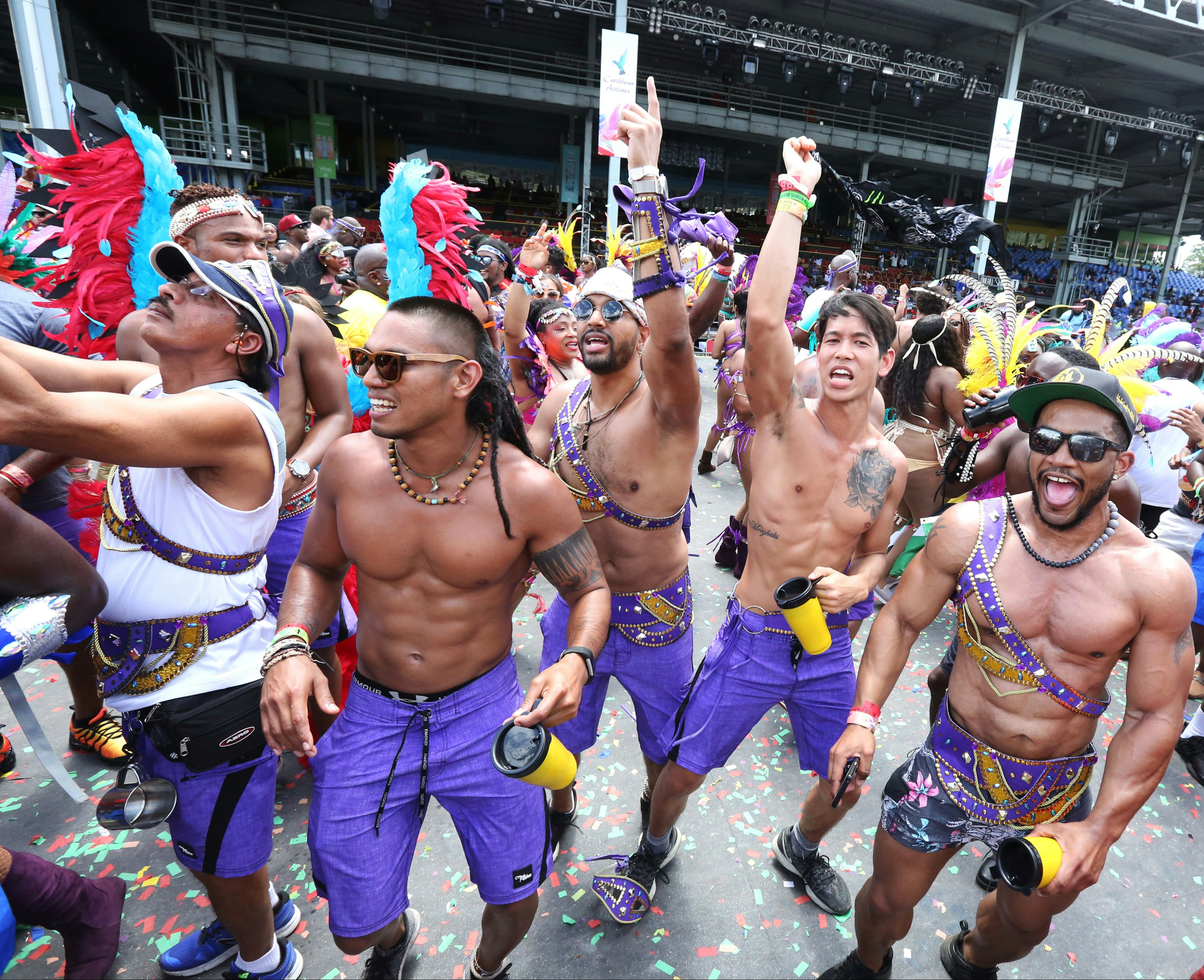 Male masqueraders in purple costume perform during Carnival in Trinidad