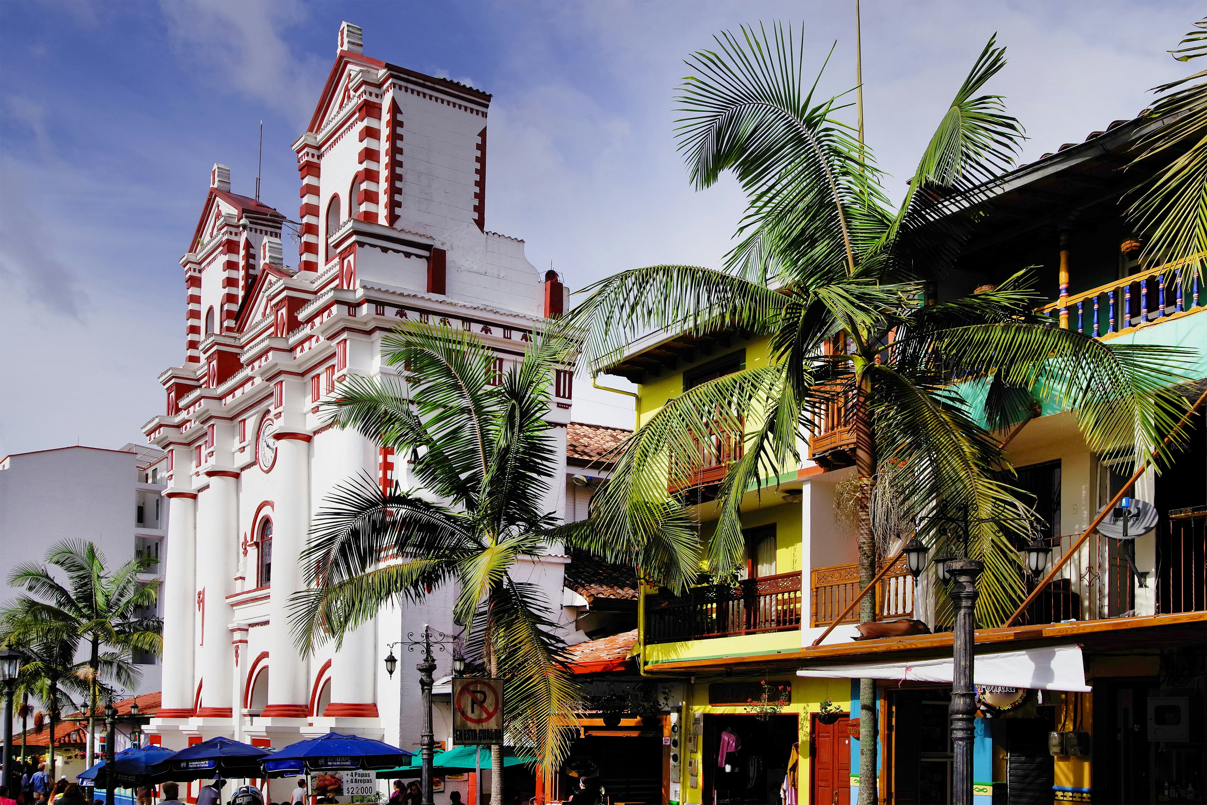 Palm trees in front of the Church Of Our Lady Of Carmen in Guatapé