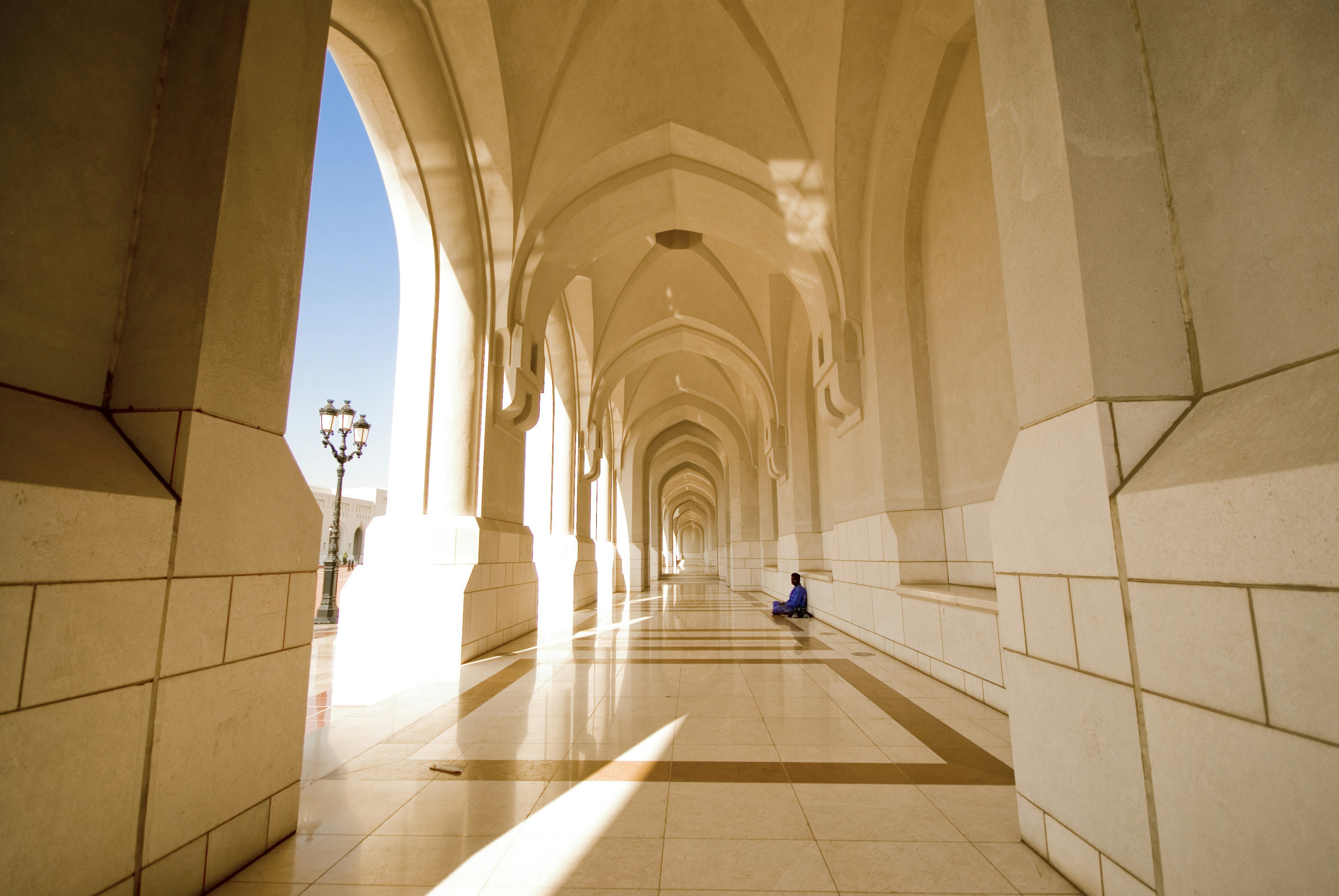 A worker rests in the shade in the Sultan's Palace in Muscat, Oman