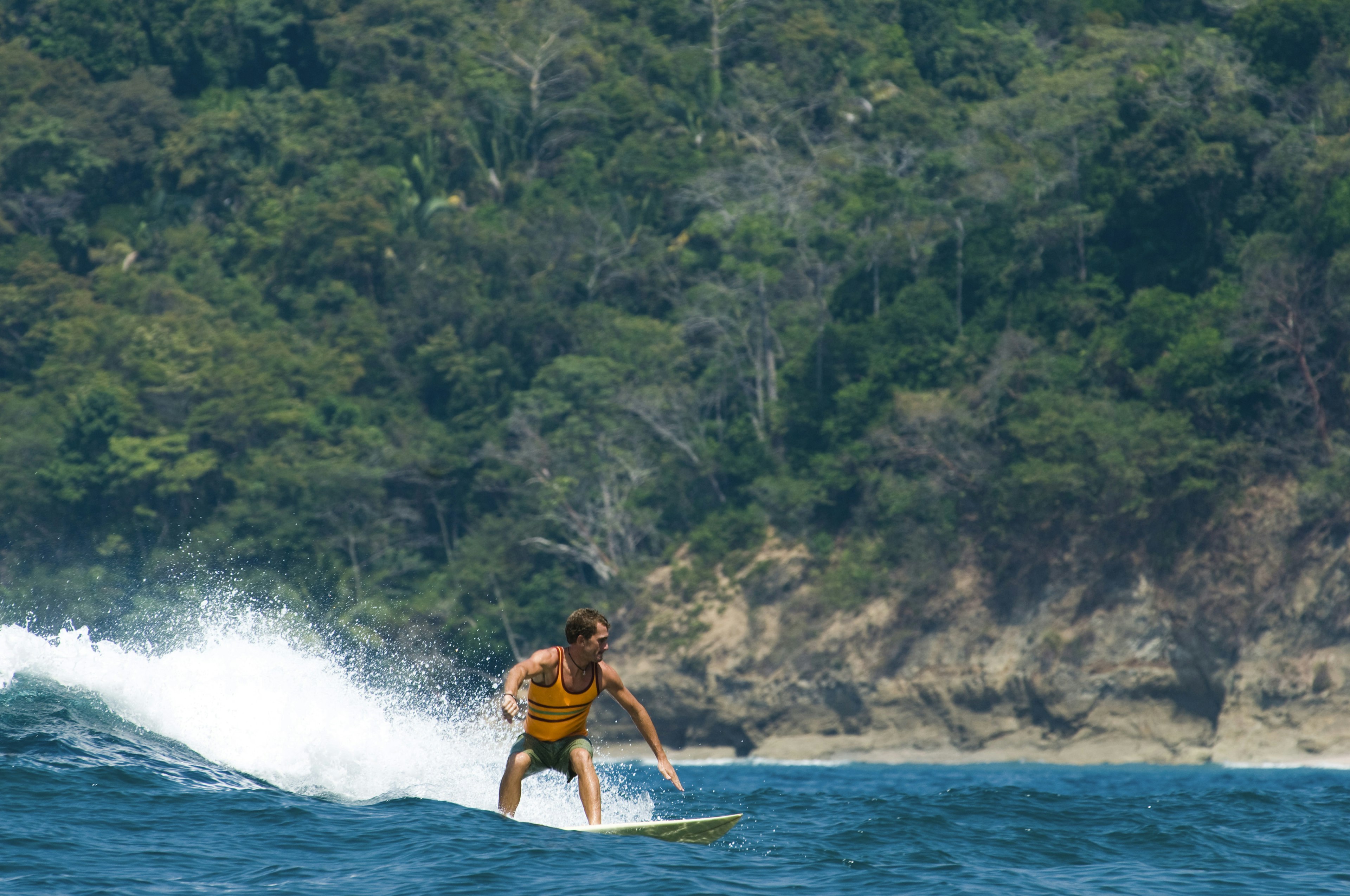 A young man surfing a wave on the coast of Dominical.