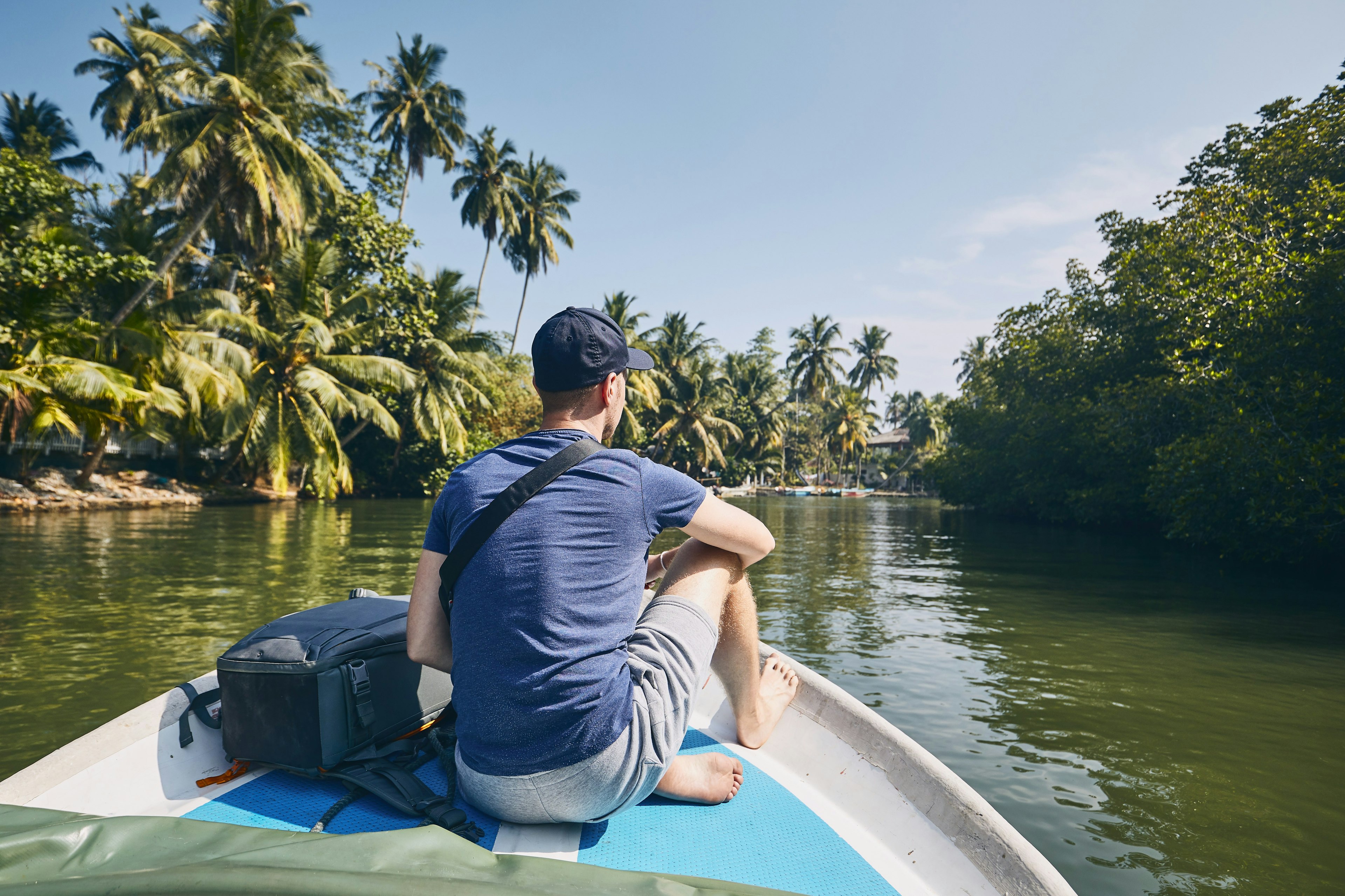 Young man on the bow of a boat in a Sri Lankan lagoon