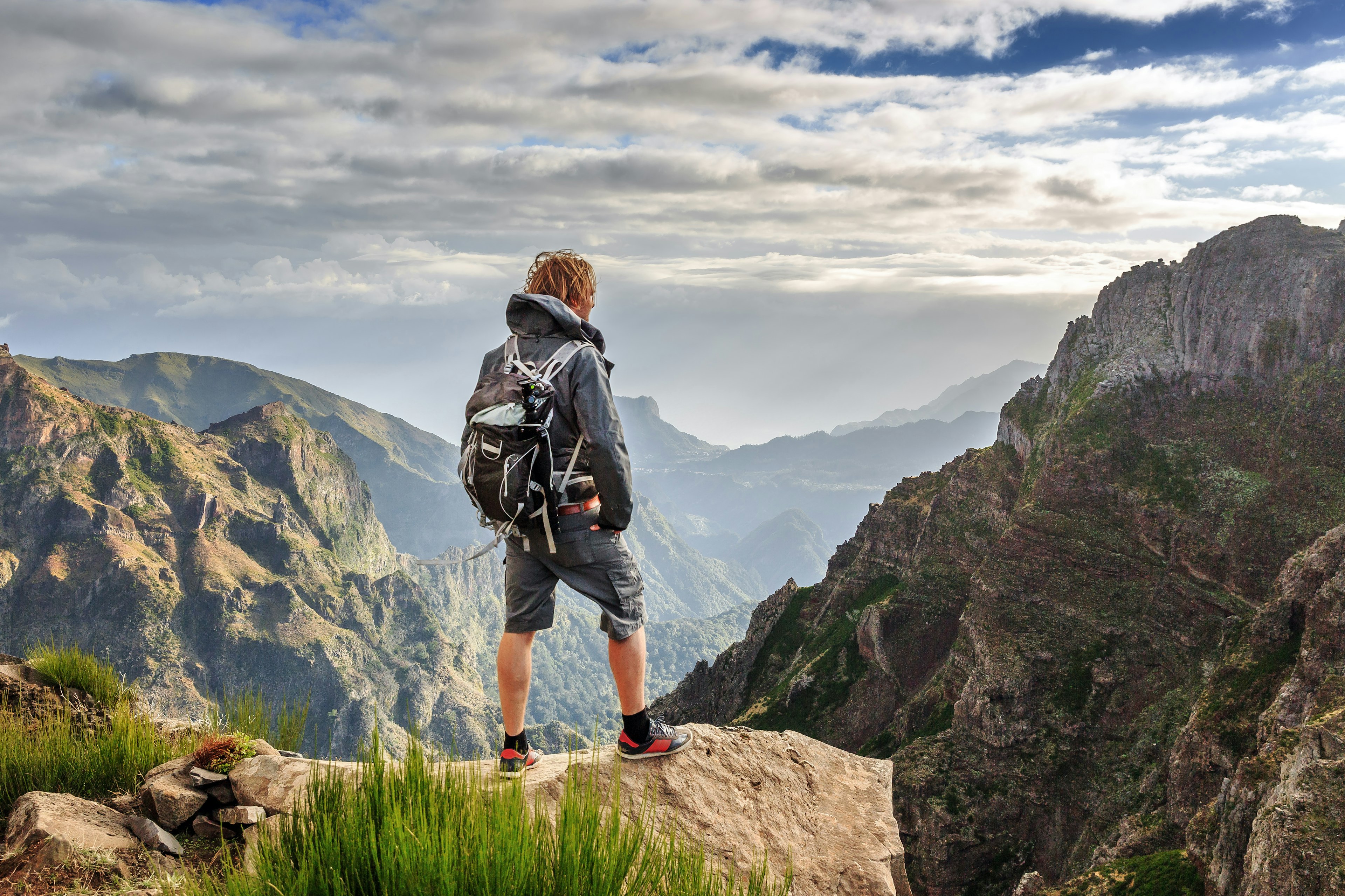 A man standing in the mountains of Madeira at Pico do Areeiro (Arieiro), while hiking to Pico Ruivo on a cloudy summer day