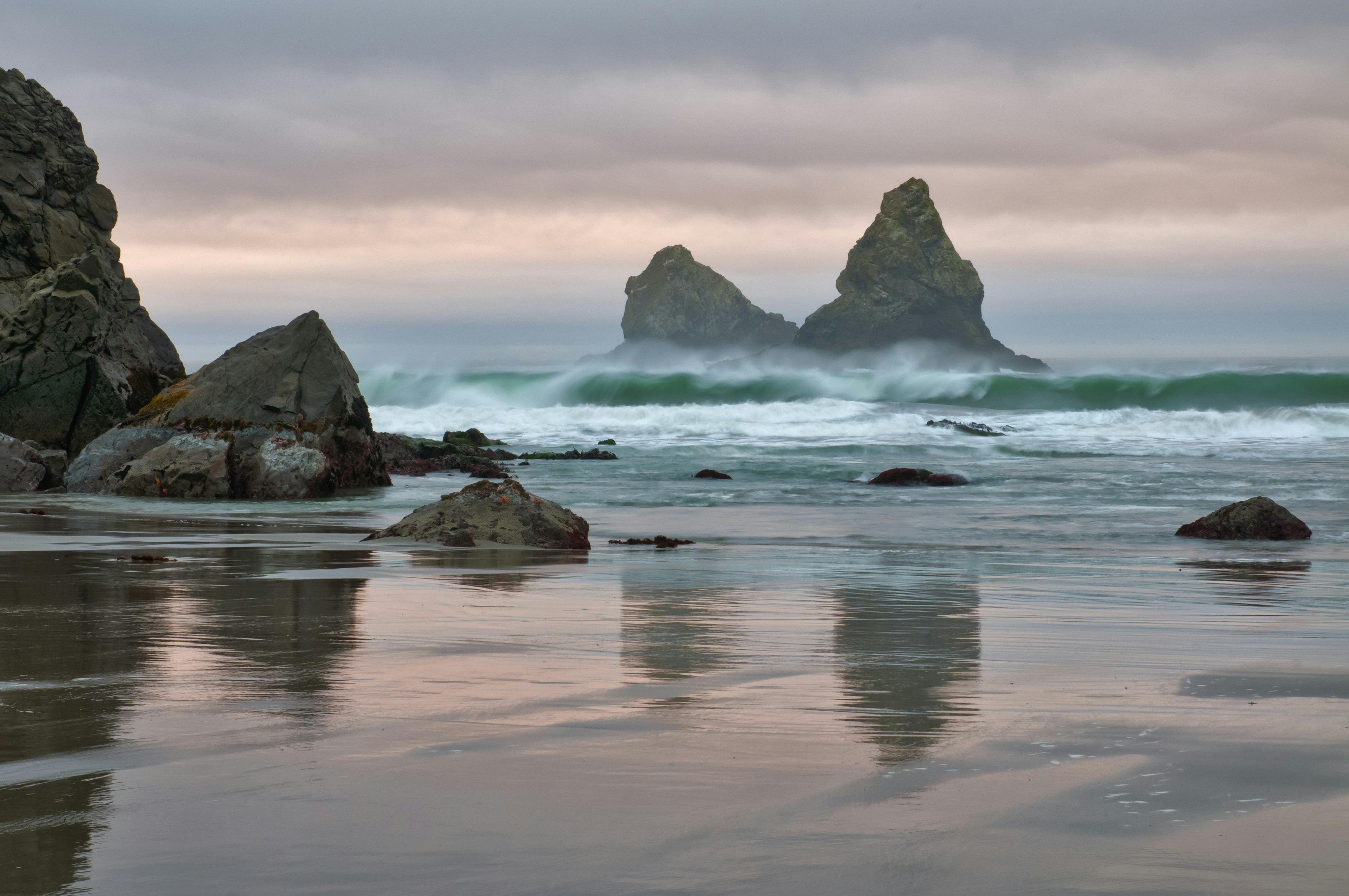 A stormy sky out over sea, with many jagged rocks sticking out of the ocean