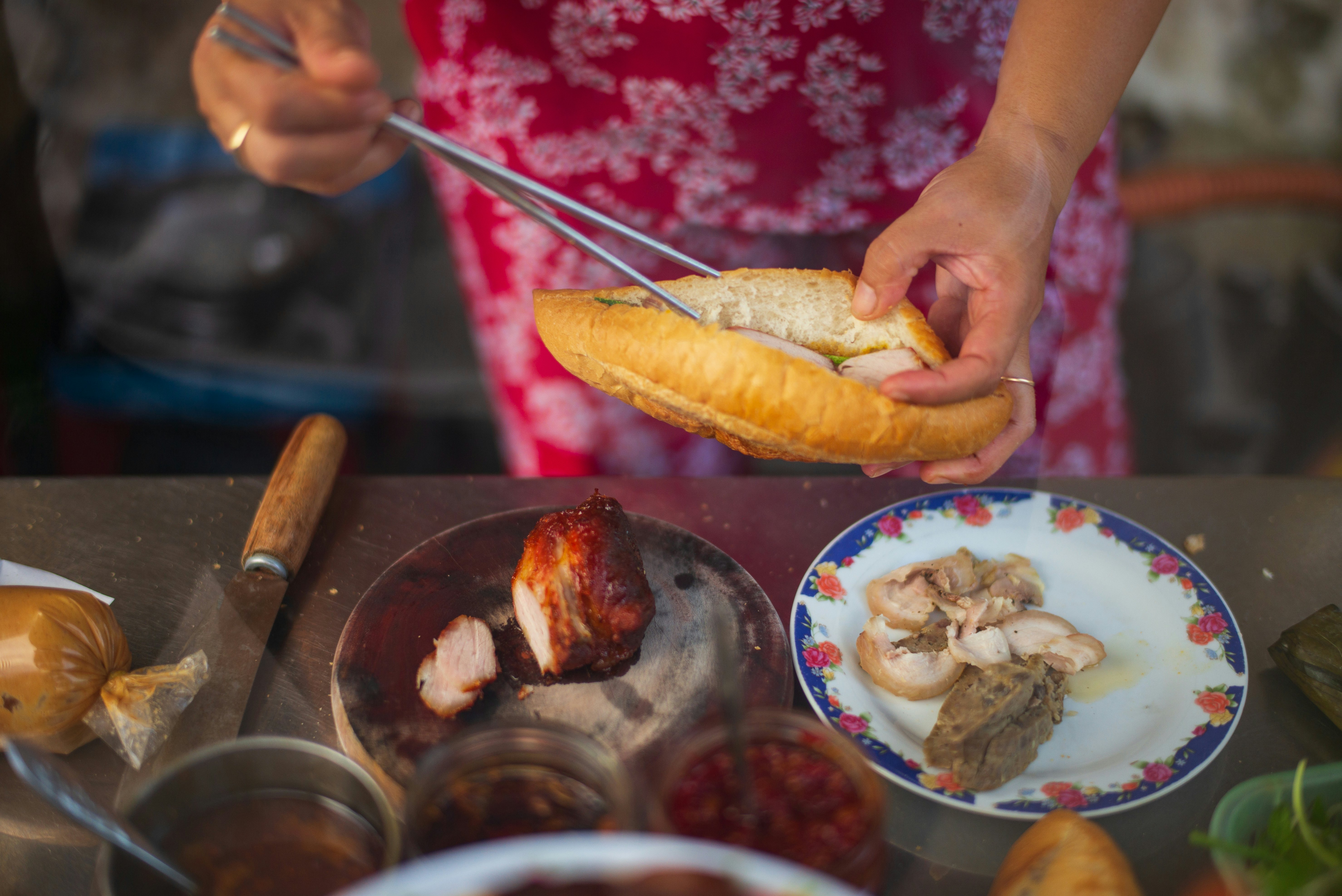 Vietnamese woman preparing street food Banh Mi in Vietnam