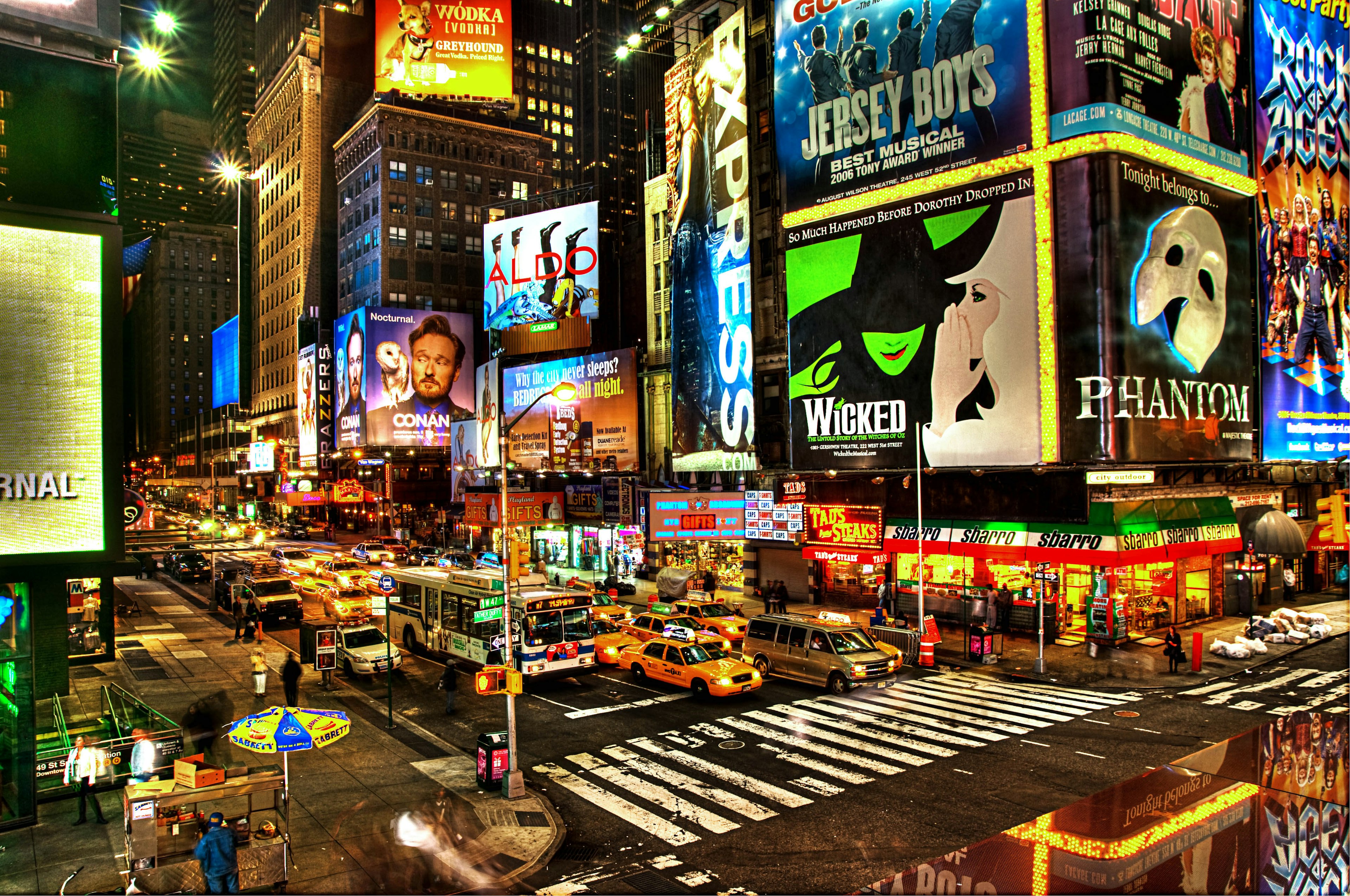 Broadway traffic and neon signs shine during dusk in New York City