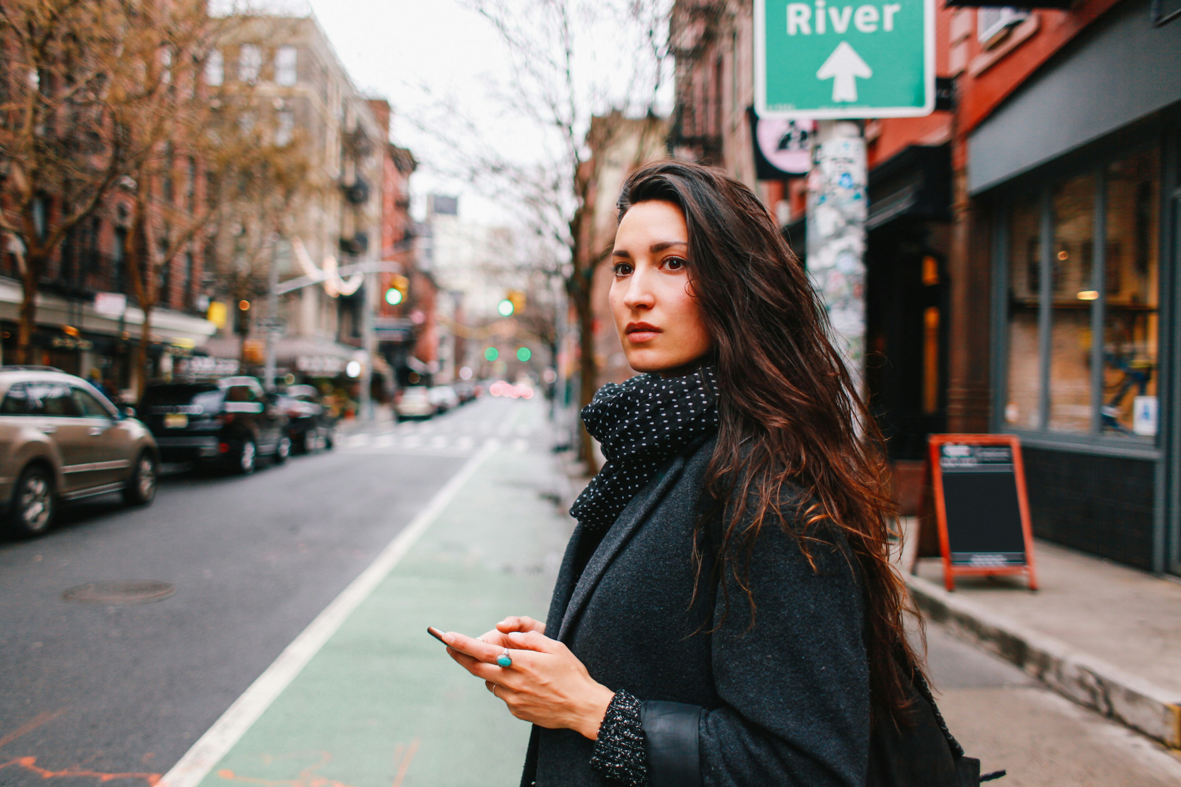 A woman on her phone searching for a ride share in Manhattan.