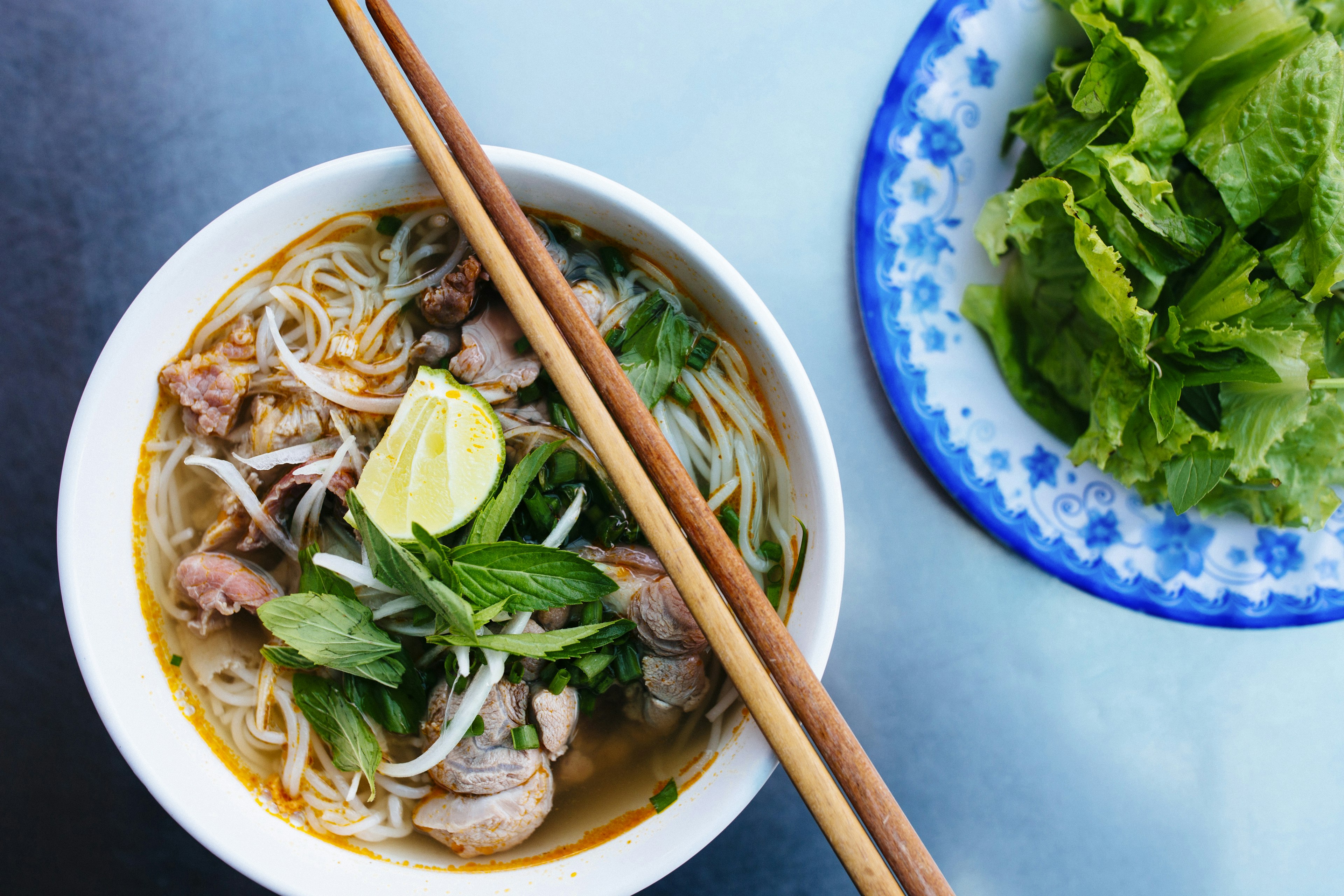 High angle close up of a bowl of bun bo hue, or beef noodle soup.