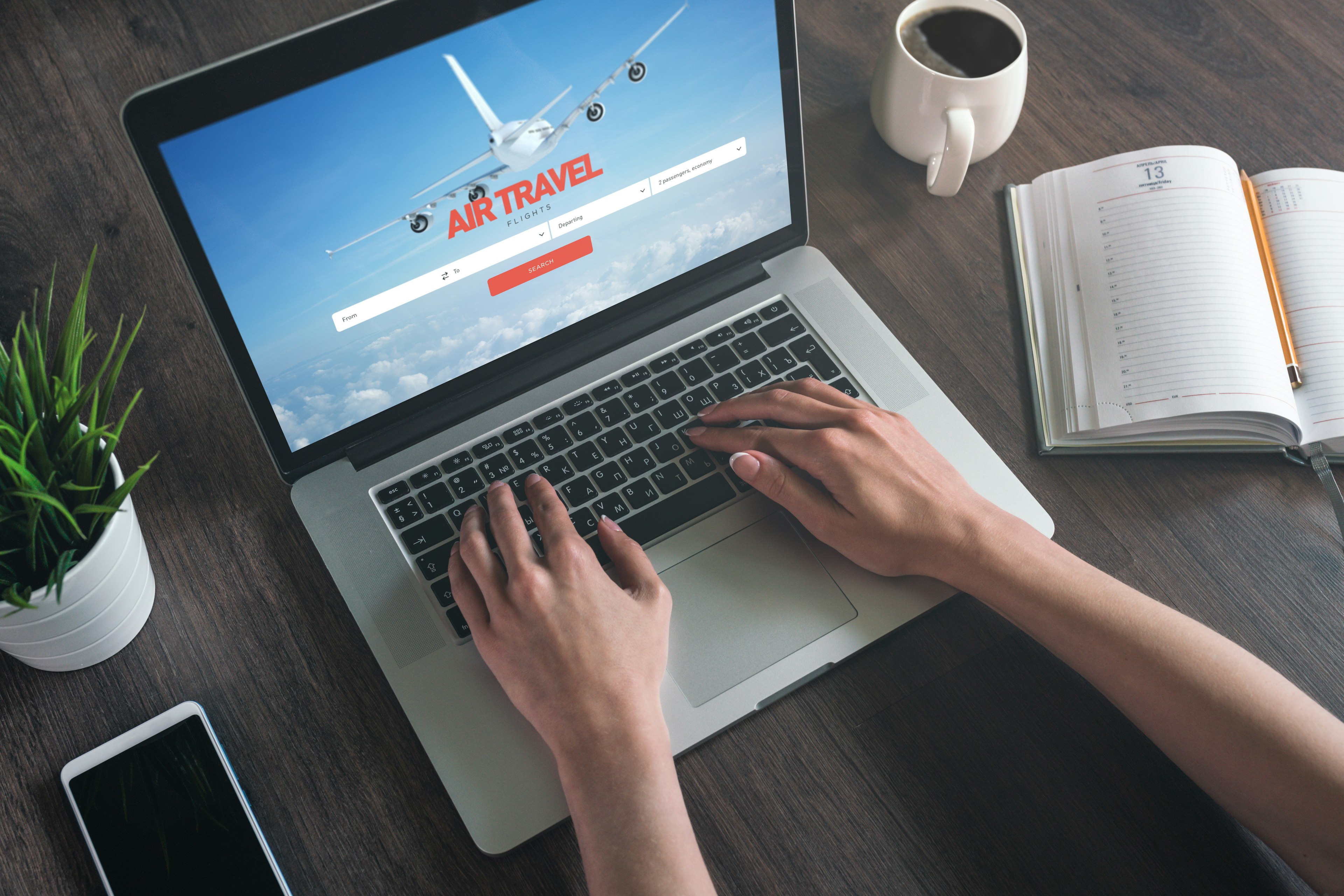 An aerial shot of a woman using a laptop to look at airline tickets